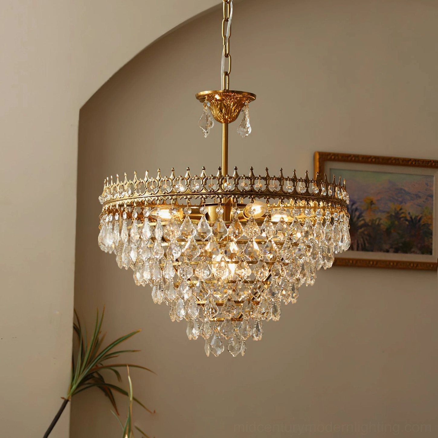 Illuminated Marilyn Crystal Chandelier low-angle close-up, tiered crystal design with glowing warm lighting on arched wall with artwork