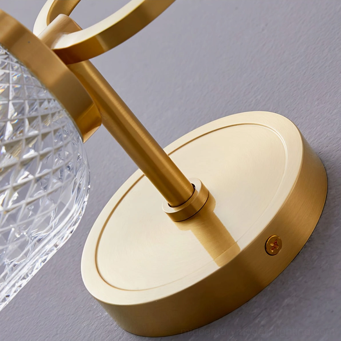 Bottom-view close-up of Marni Wall Sconce brushed brass wall base with metal connecting rod and visible mounting hardware