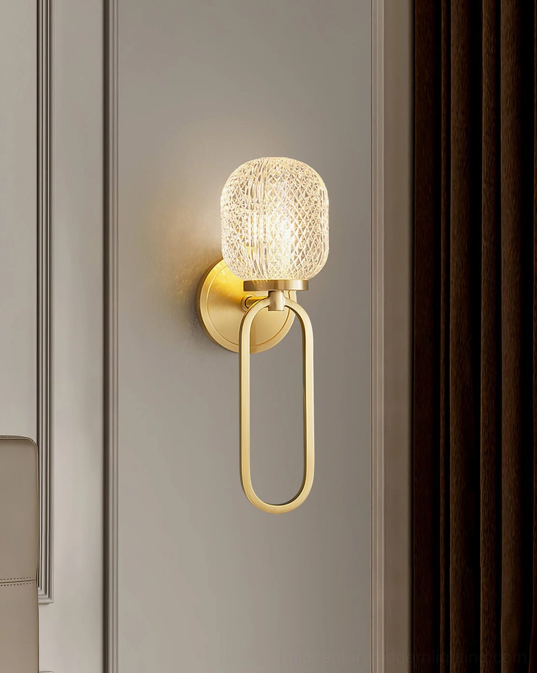 Side profile view of Marni Wall Sconce showing oval brass gold loop bracket and textured cylindrical glass lampshade