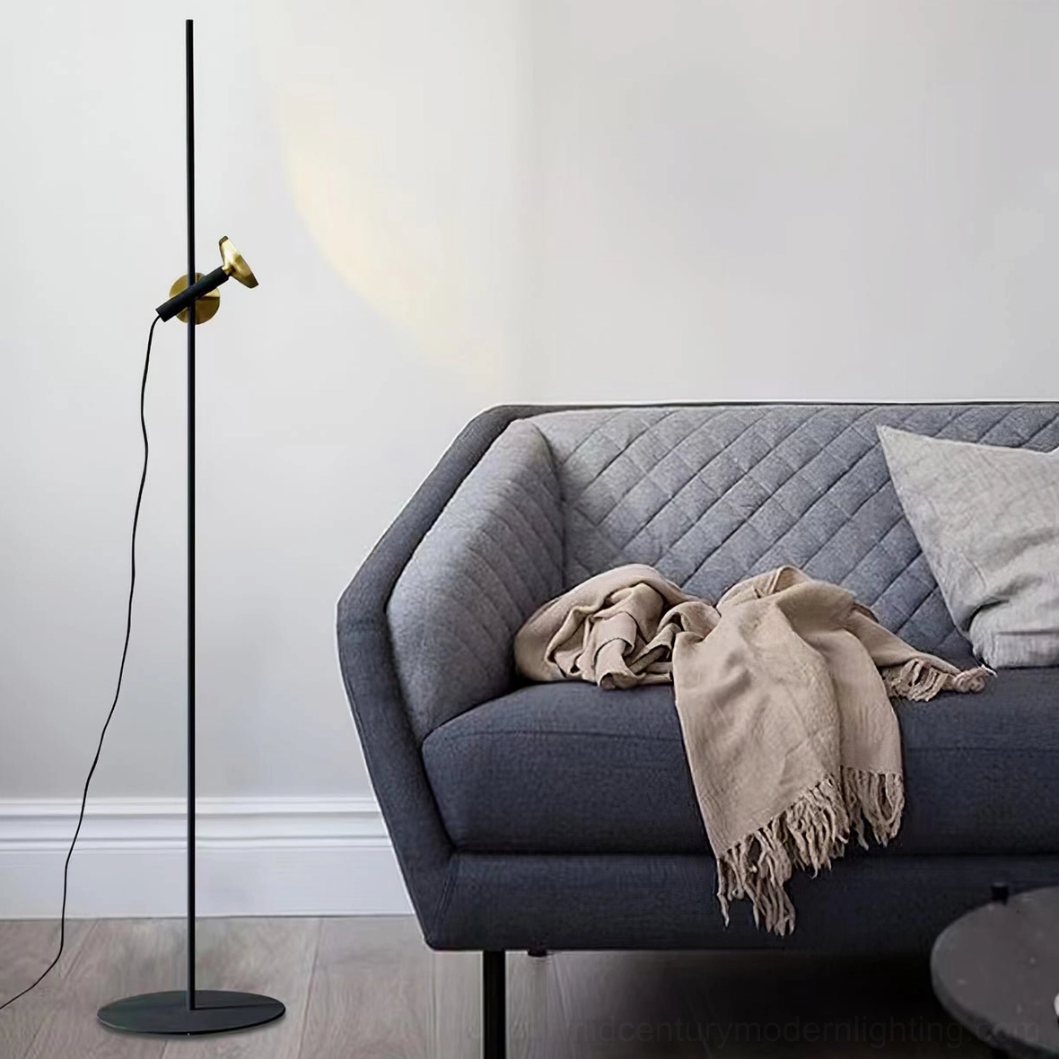 Adjustable Marquina floor lamp in modern living room with grey sofa, black metal pole design side view