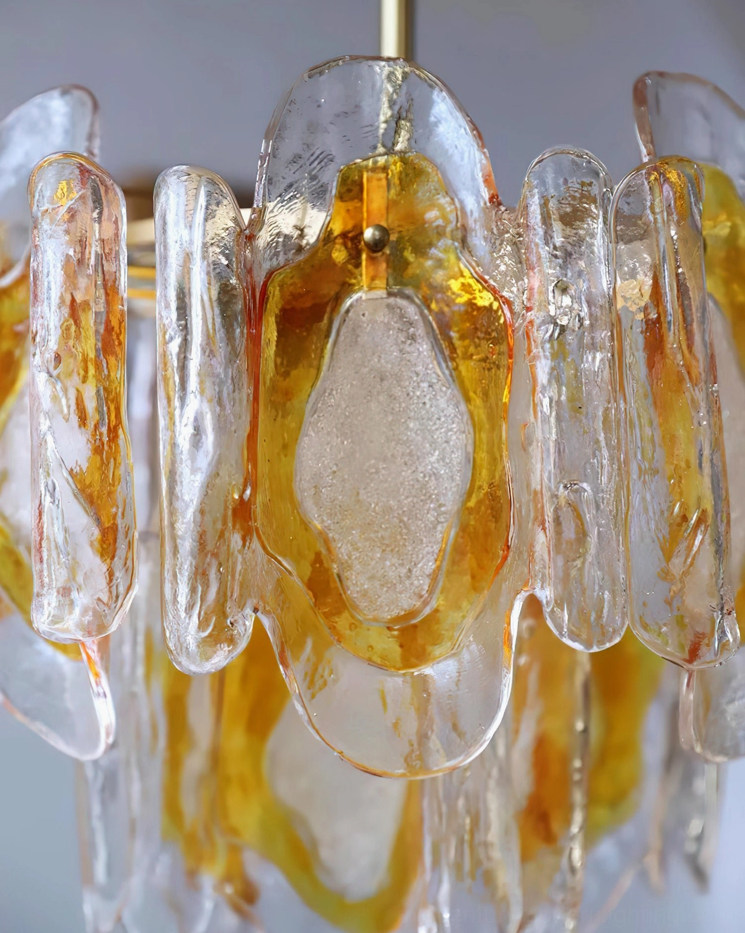 Marrina double-tiered amber glass chandelier three-quarter front view with warm gold metal hardware and organic glass design