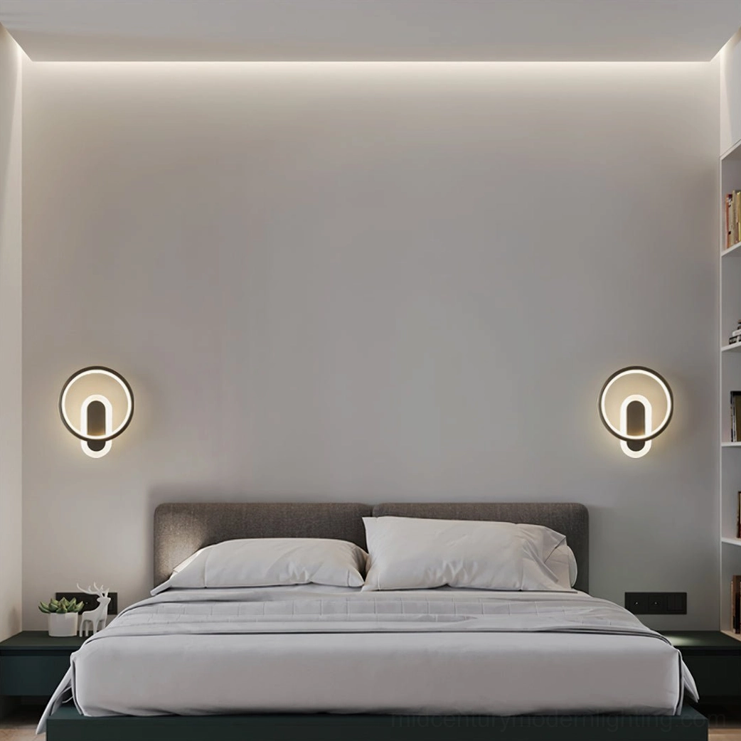 Pair of matching round brass wall lamps mounted symmetrical on master bedroom headboard