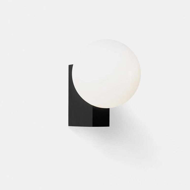 Matte black globe wall sconce with frosted white glass shade demonstrating modern minimalist lighting design