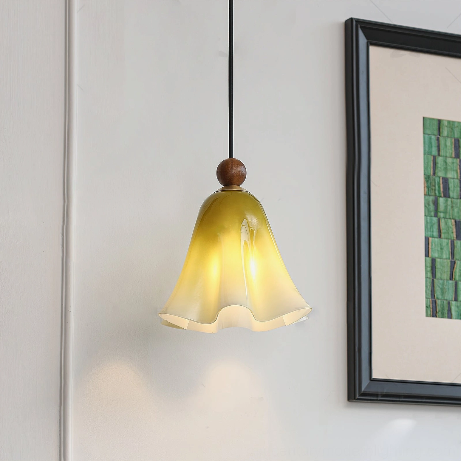 Green yellow gradient Meblo pendant light hanging in contemporary home with framed wall art and warm ambient lighting