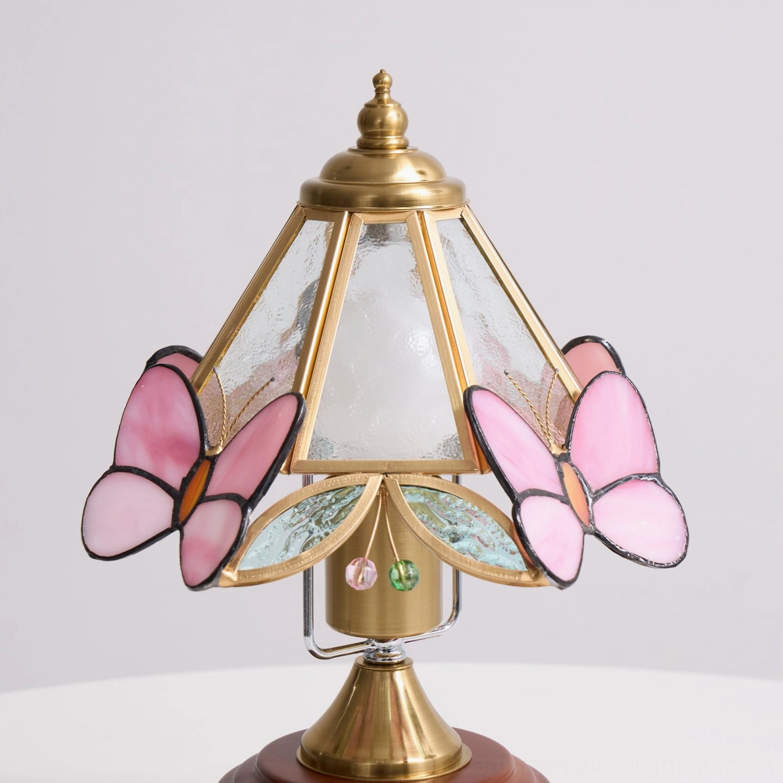 Mid-century modern butterfly table lamp with walnut wooden base and pink stained glass butterflies, three-quarter profile