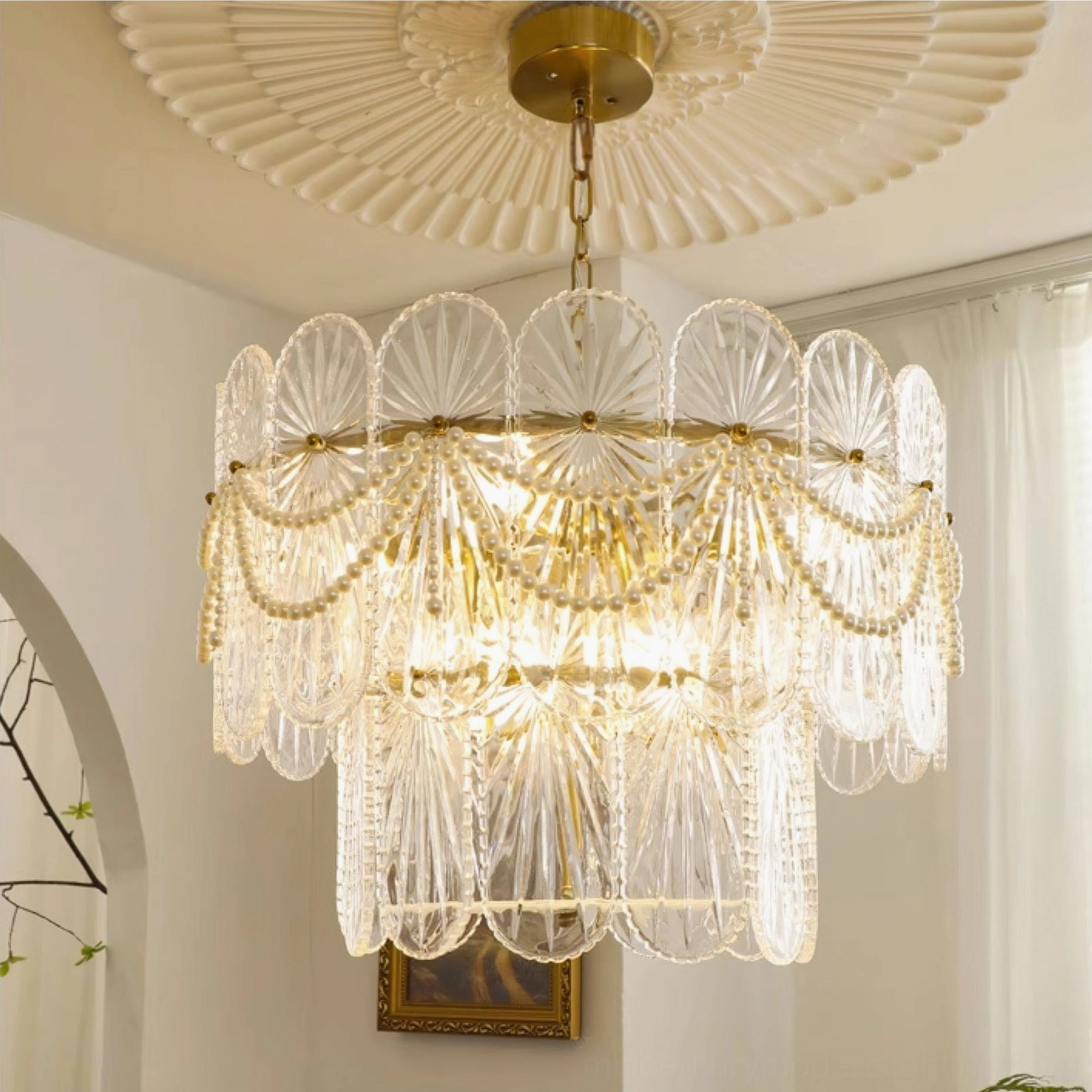 Mid-century modern tiered glass chandelier with scalloped edges and gold ceiling rose in entryway setting