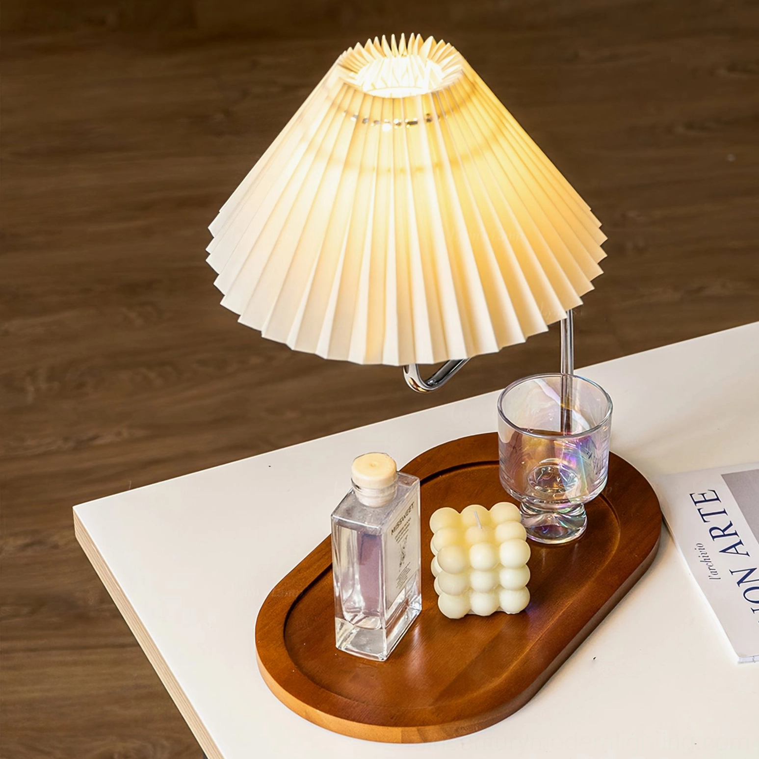 Overhead view of mid-century table lamp with wooden tray on wood surface, magazine underneath