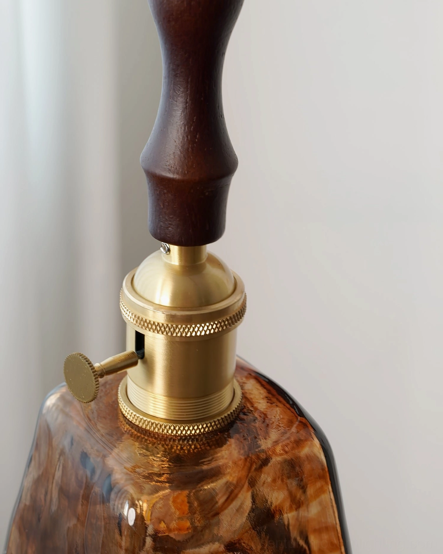 Mid-century modern pendant with glass and wood construction mounted above interior living space