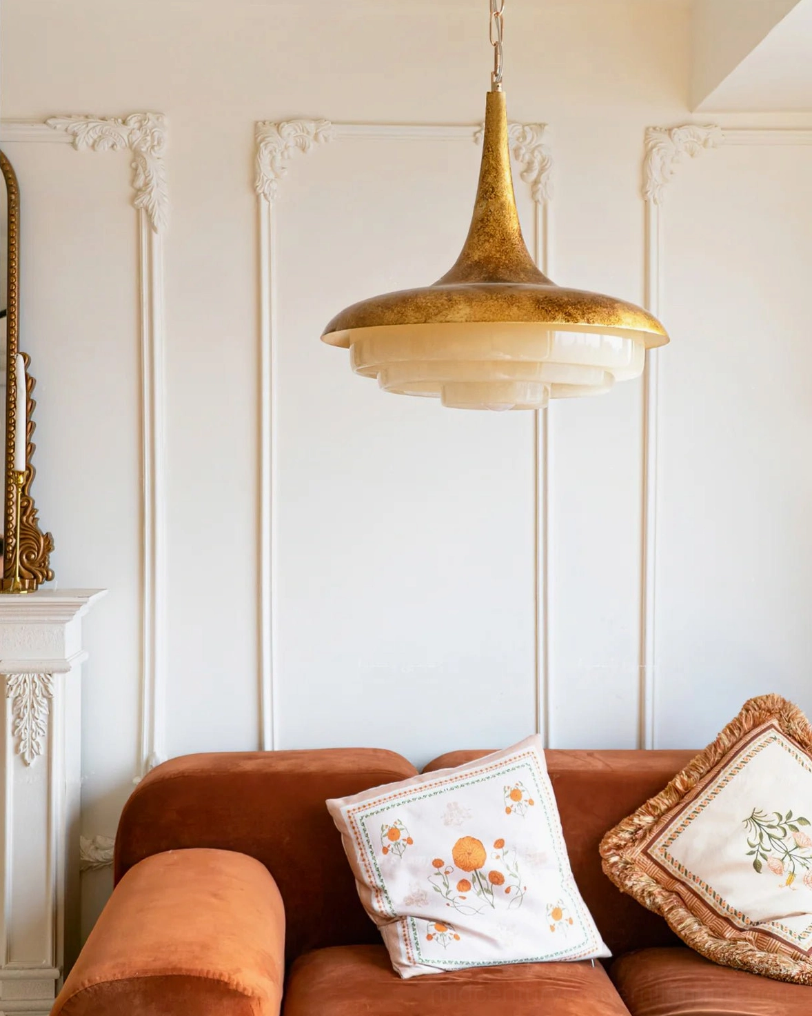 Tiered pendant light illuminated in French style living room with velvet sofa warm ambient glow