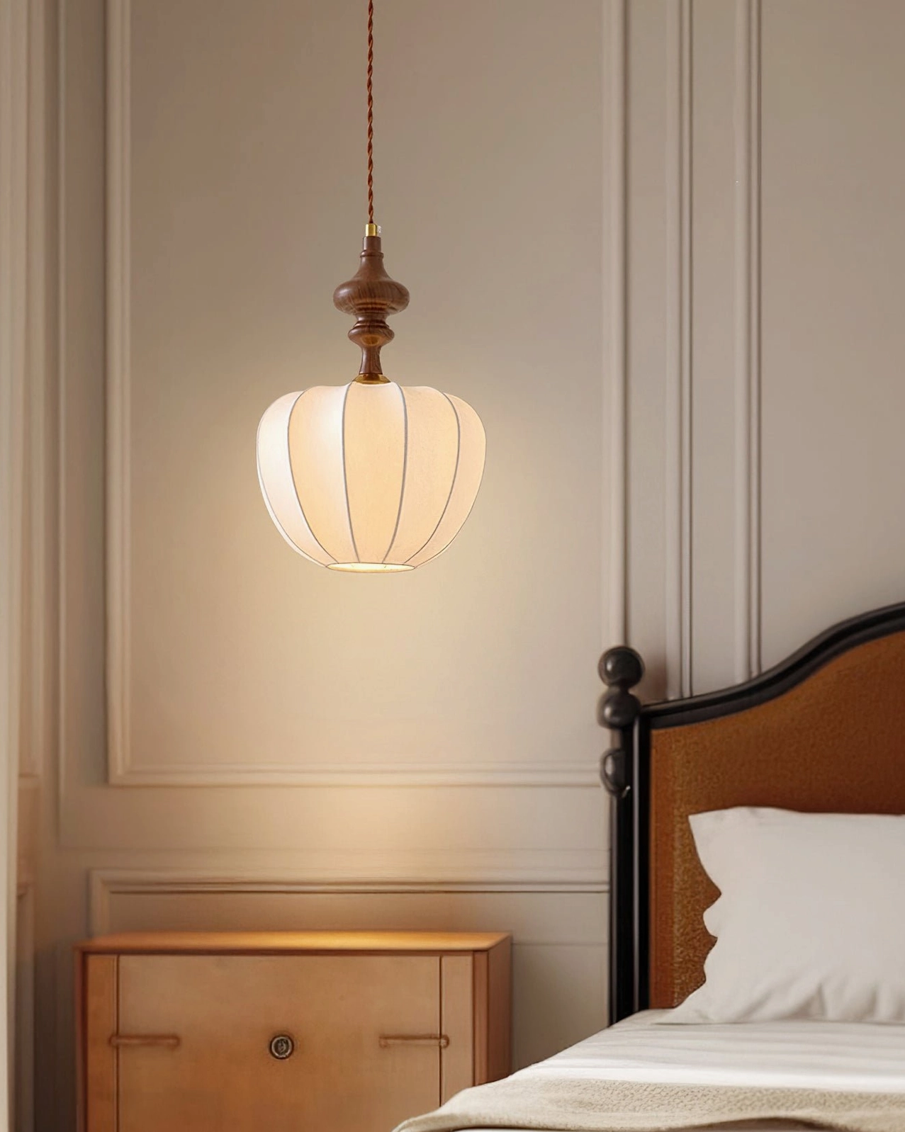 Round ribbed fabric pendant shade with dark wood accents mounted above wooden nightstand