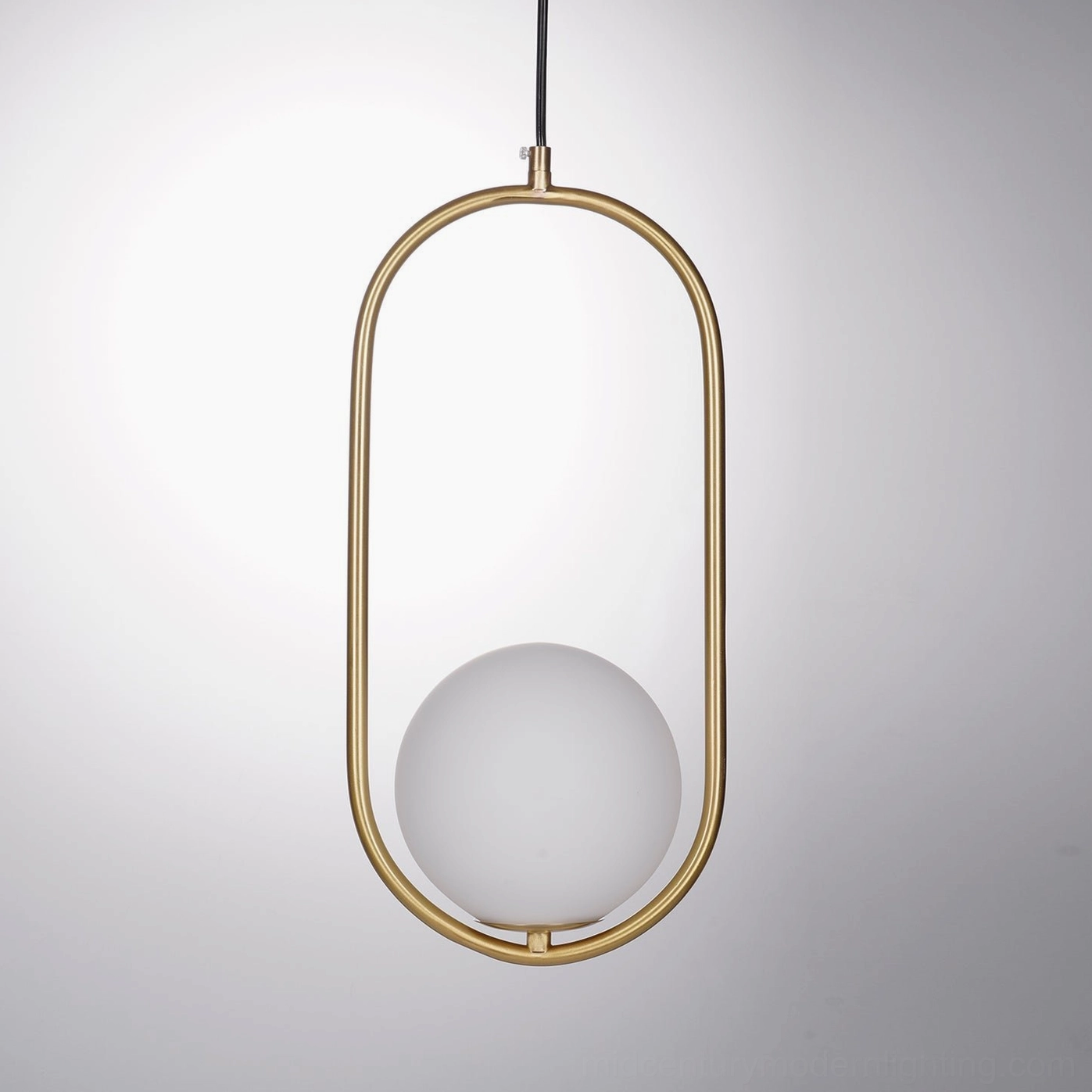 Mila pendant light in brass finish showing warm metallic shine with frosted white glass diffuser in minimalist interior setting