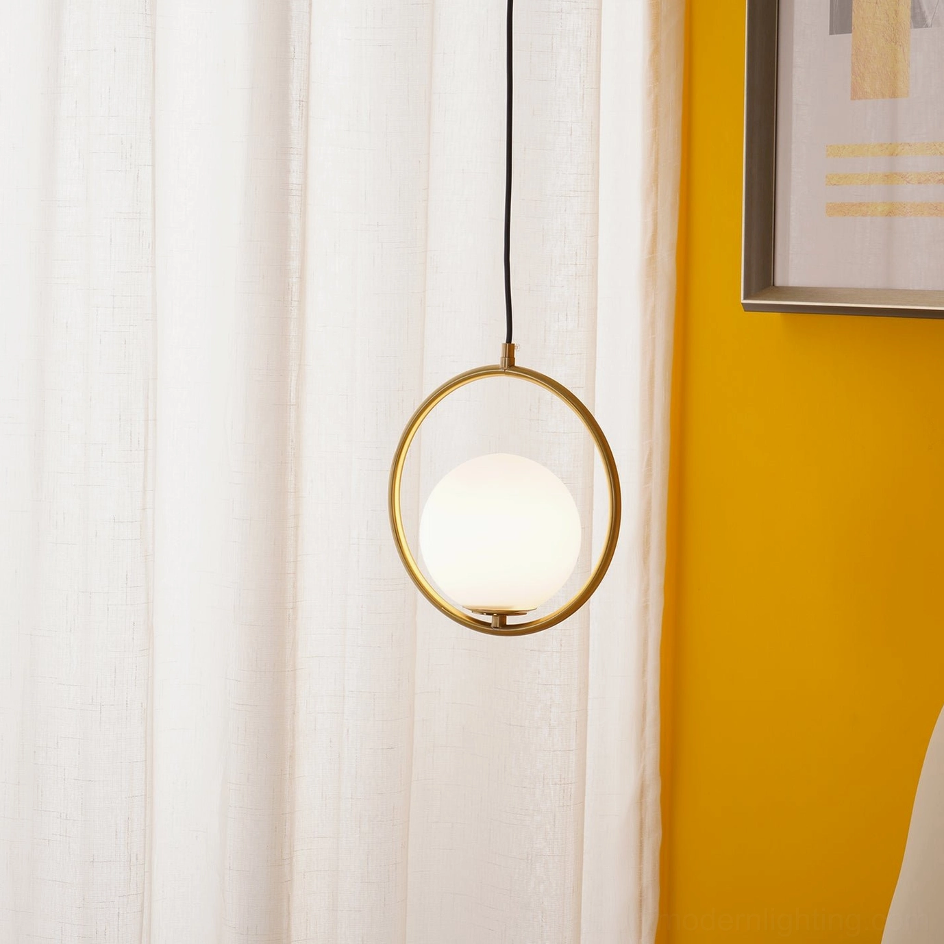 Mila hoop frame pendant light with gold metal finish and frosted white glass shade in bedroom with sheer curtains and orange wall
