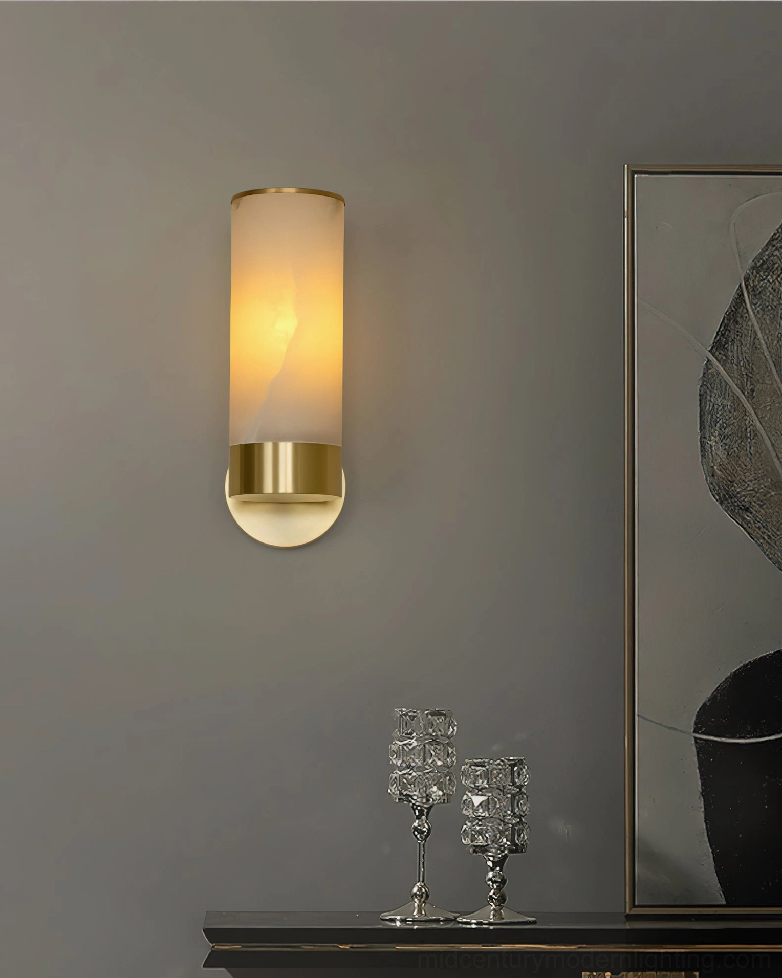 Minimalist alabaster wall sconce with round brass bottom cap and warm diffused light, front flat view decorative styling