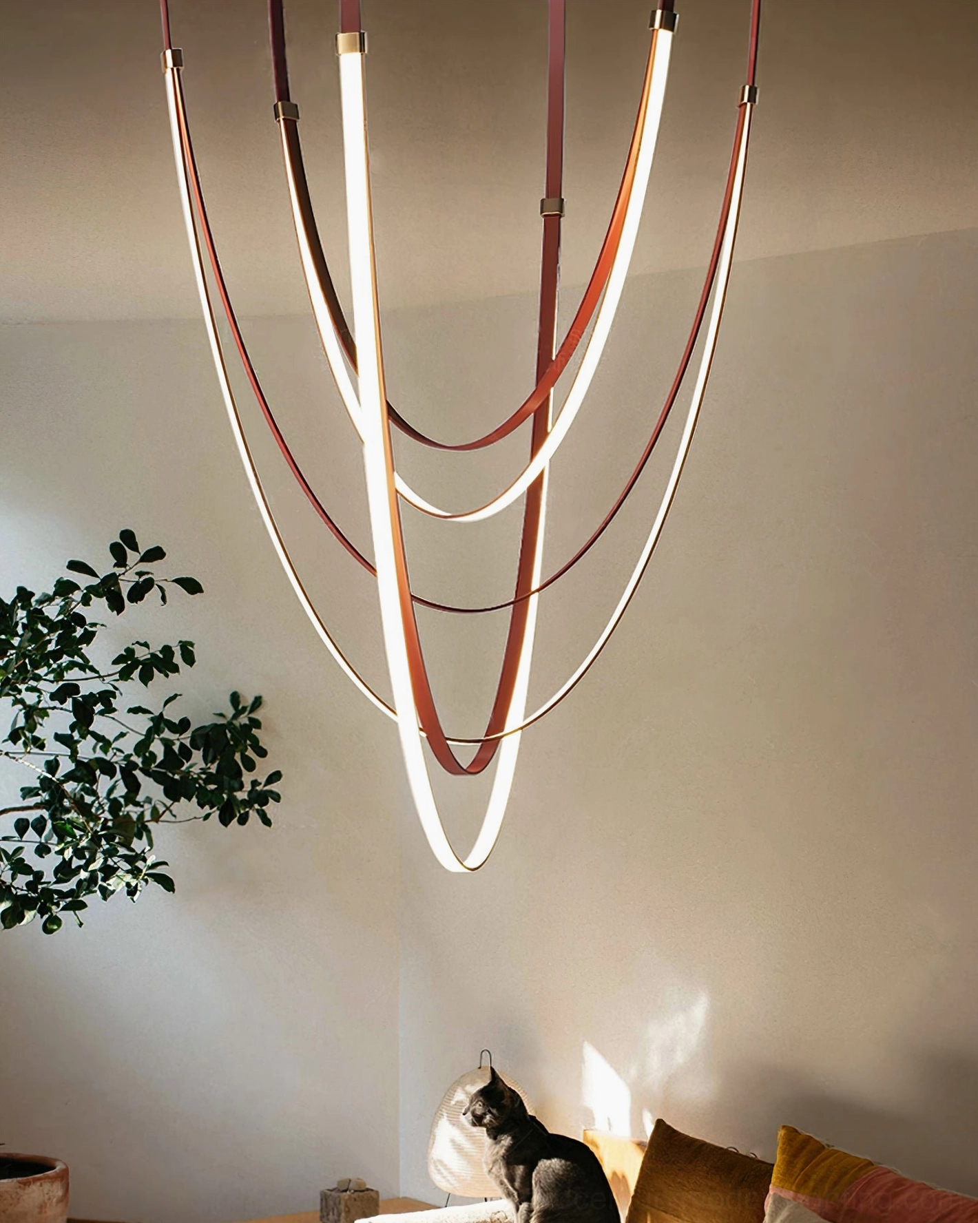 Minimalist curved leather pendant lamp with warm lighting in cozy residential living room with comfortable seating