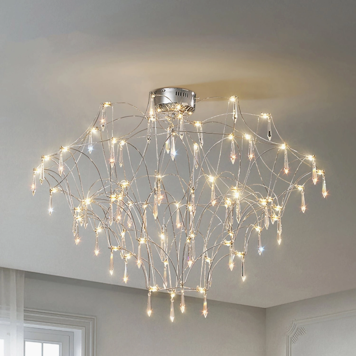 Mira crystal chandelier installed in minimalist grey living room with warm LED lighting and firework-style crystal arrangement, low-angle ceiling view