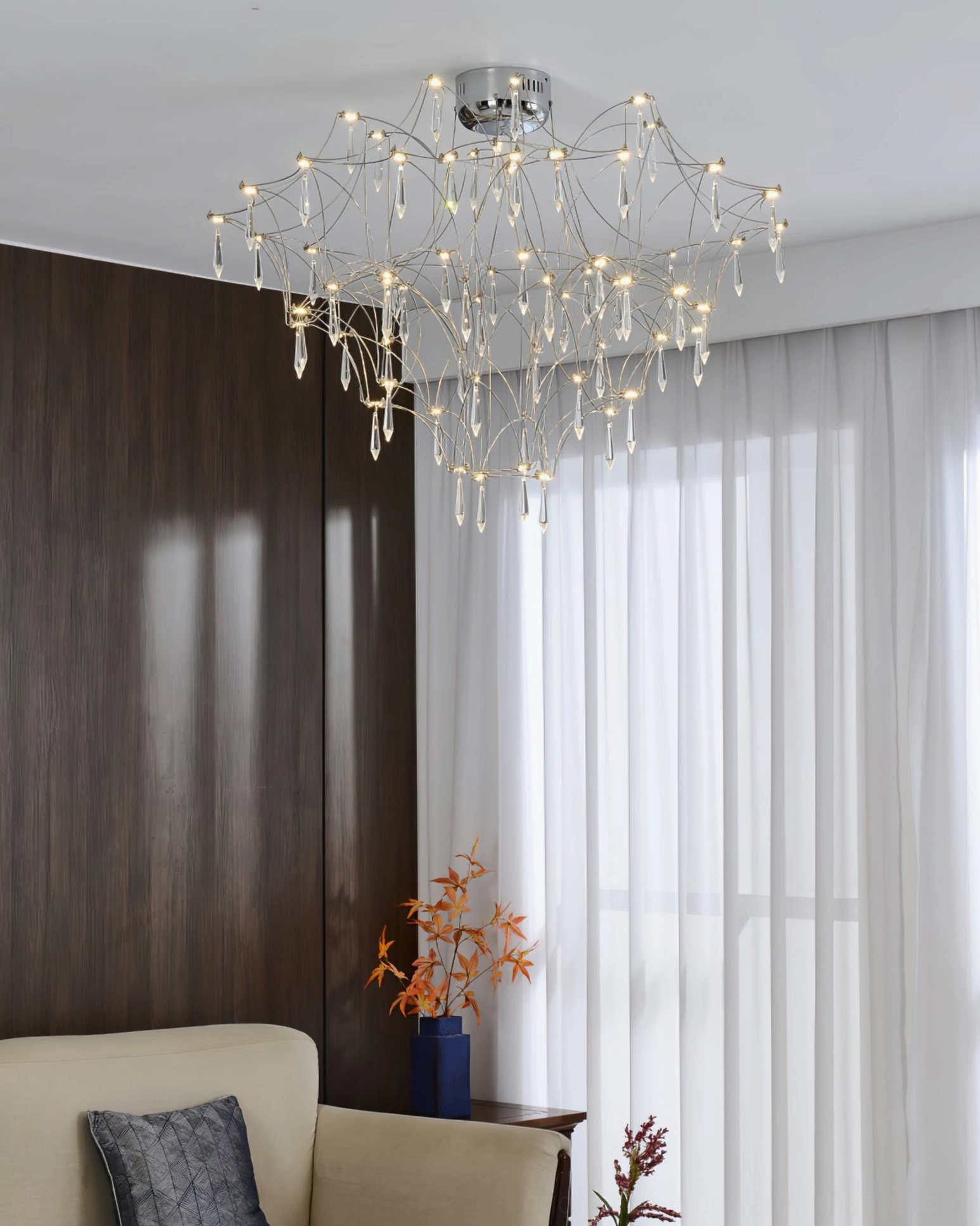 Mira modern crystal chandelier in cozy contemporary sitting area with sheer curtains and neutral home decor, oblique downward perspective