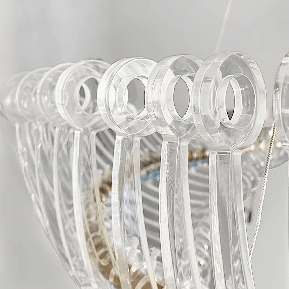 Contemporary Möbius crystal chandelier mounted on white ceiling with visible cable length and installation detail