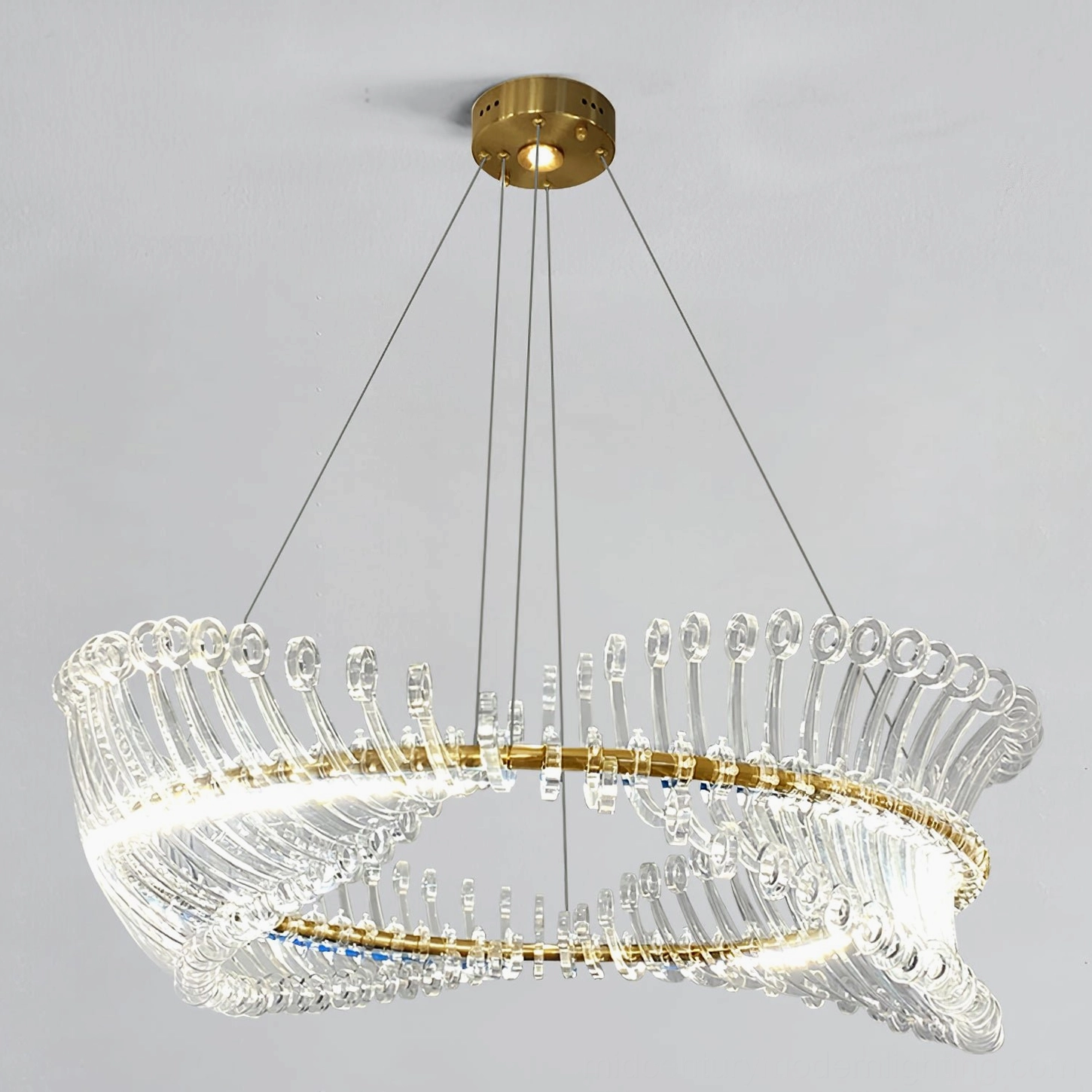 Modern Möbius strip gold chandelier paired with mid-century modern furniture in contemporary dining room