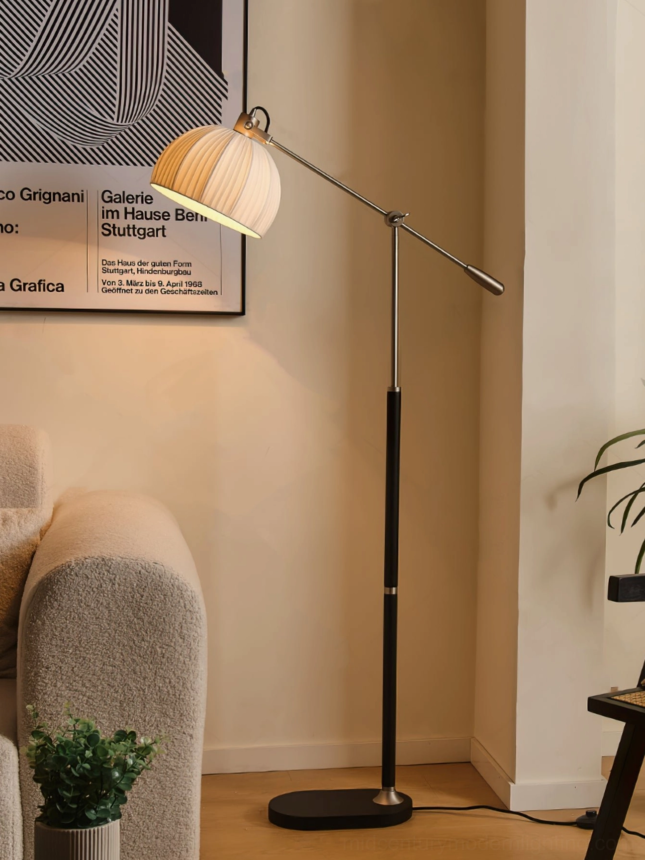Modern black metal floor lamp with pleated shade in minimalist living room interior with wall art and contemporary furnishings