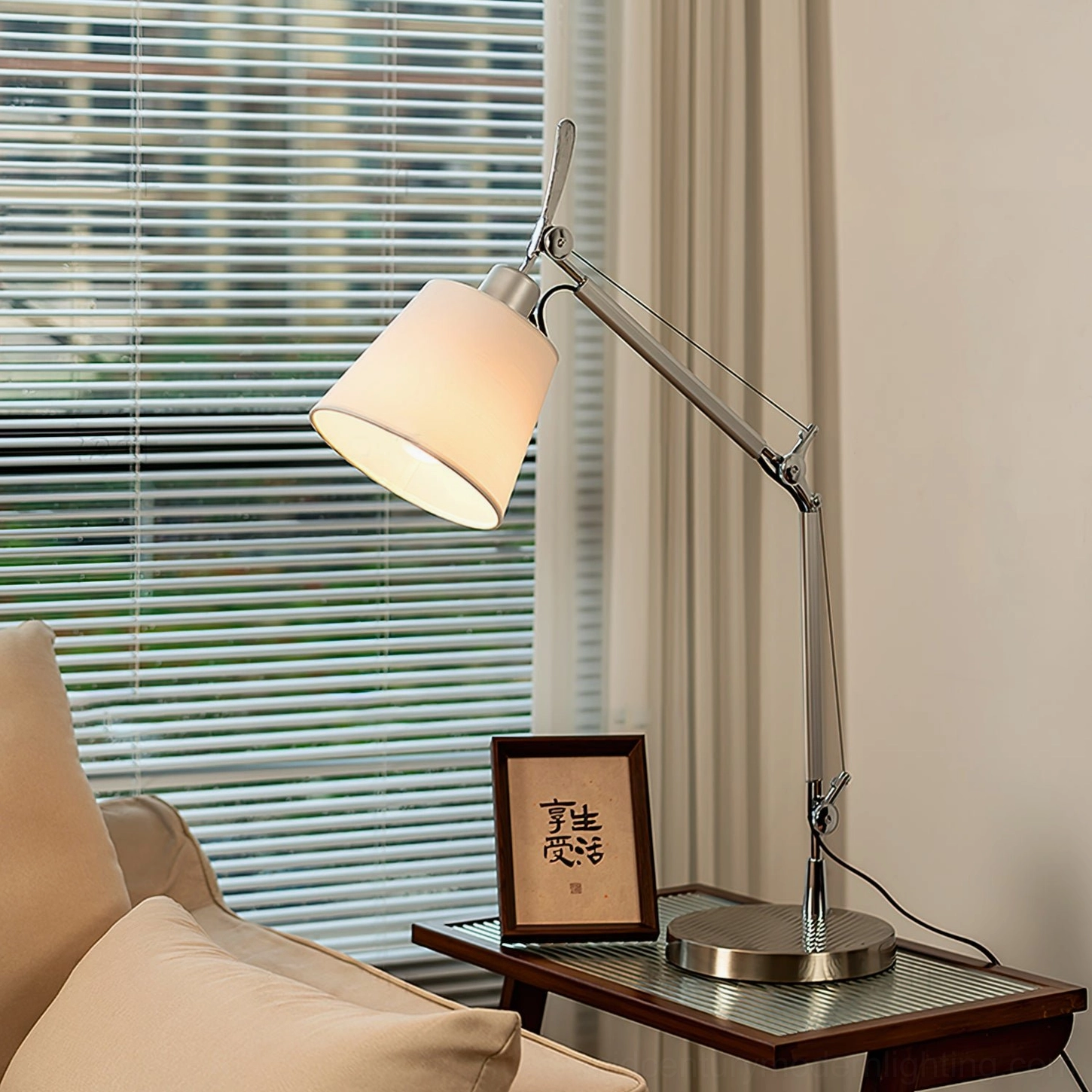 Contemporary adjustable table lamp lit in living room setting, showcasing warm light and sculptural design on side table with sofa backdrop