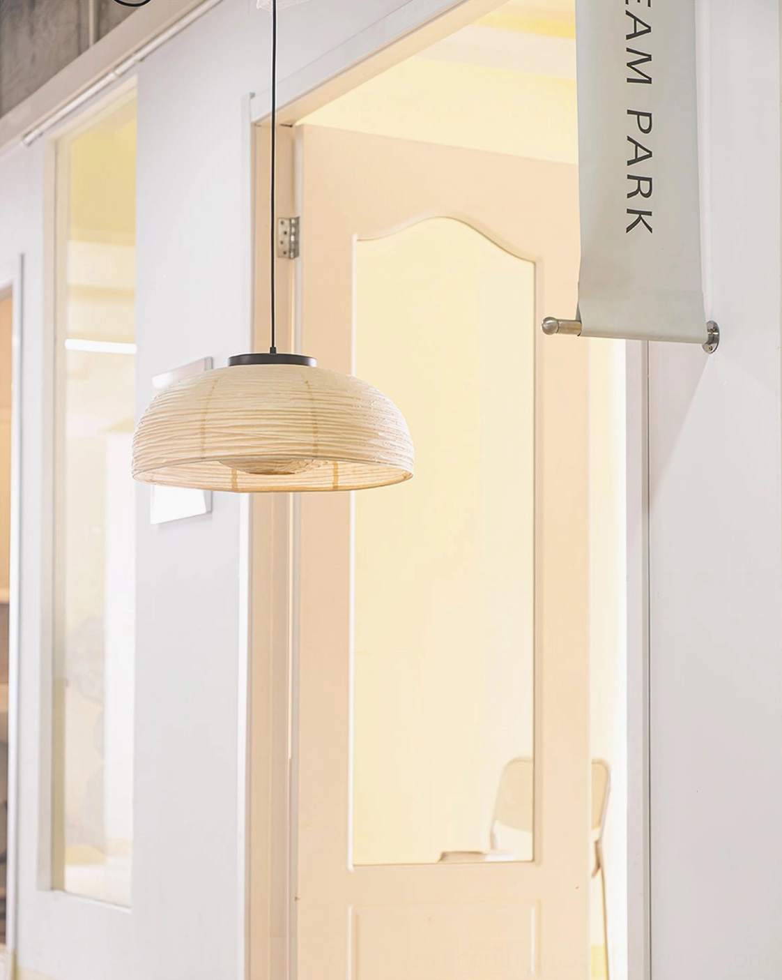 Modern ceiling pendant lamp in office doorway – woven paper dome sculptural design