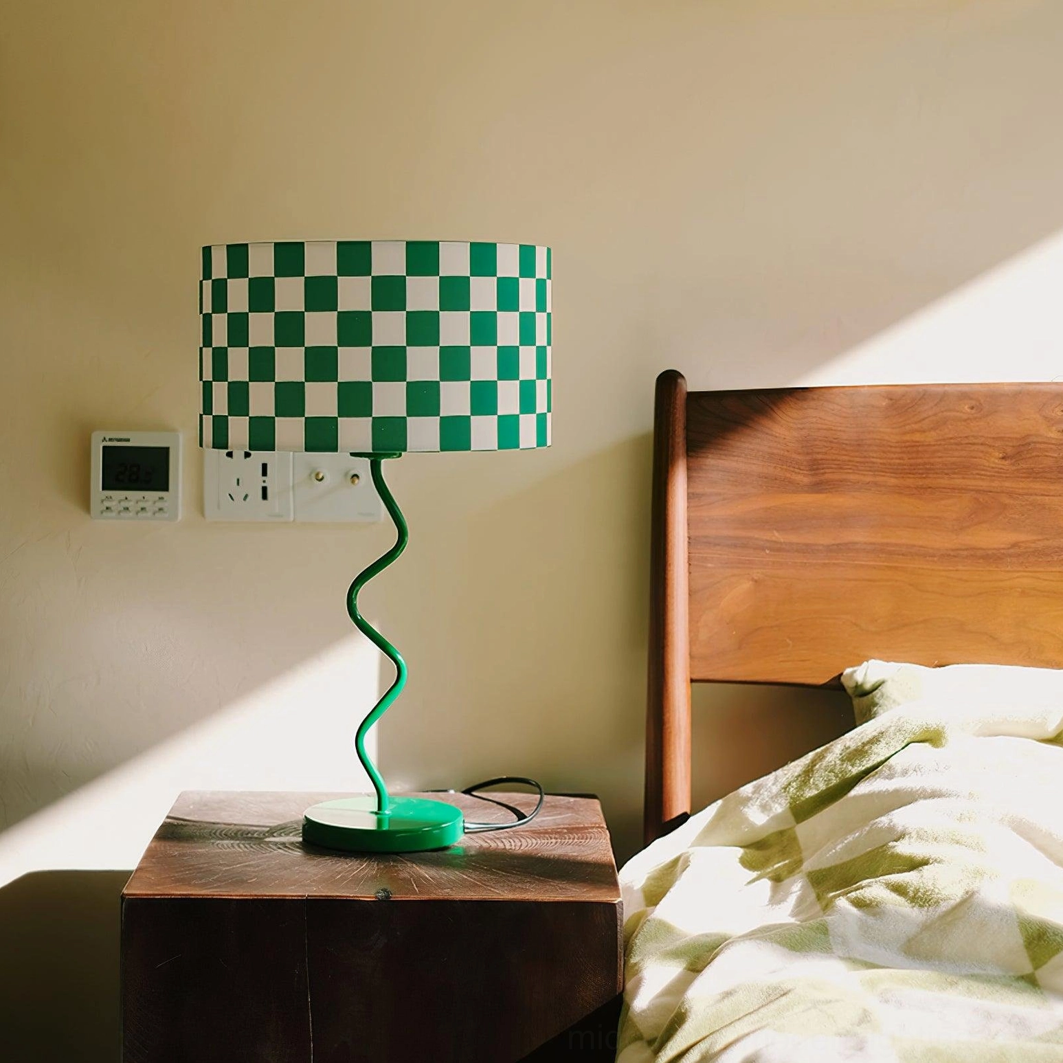 Contemporary geometric table lamp on dark wooden bedside table next to bed for bedroom lighting