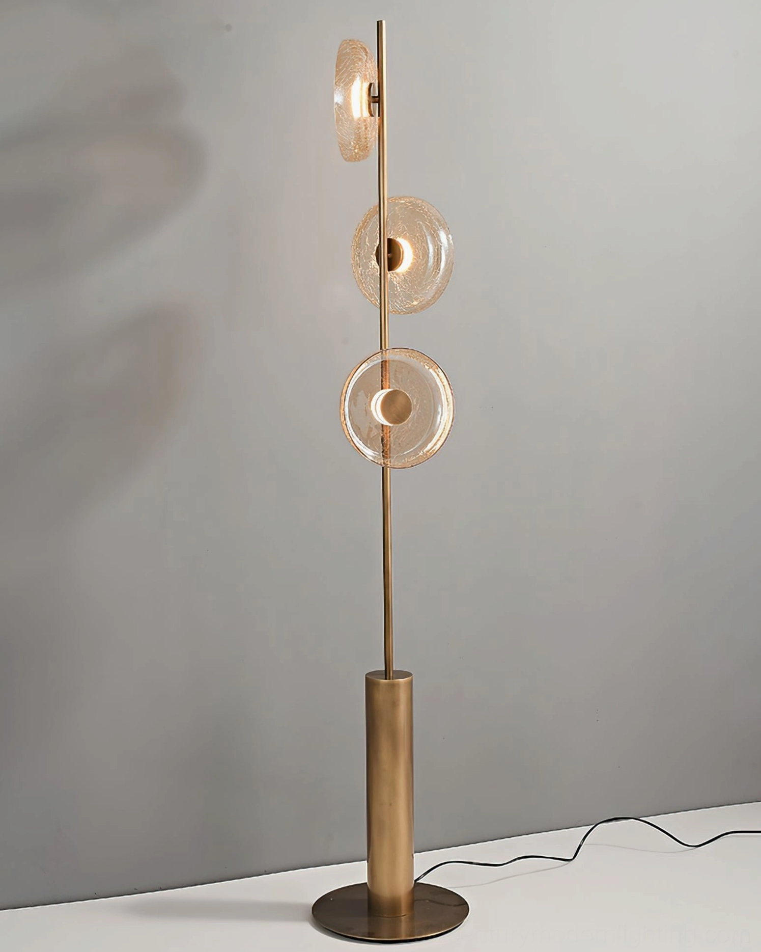 Modern sculptural crackle glass floor lamp displaying fractured light refraction and bronze base elegance