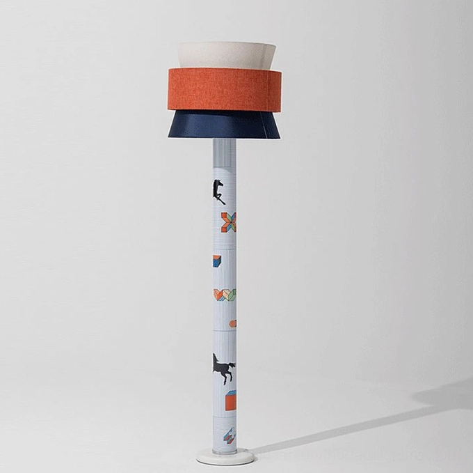 Modern playful standing lamp with tri-color shade, angled view showing woven fabric detail and printed decorative pole