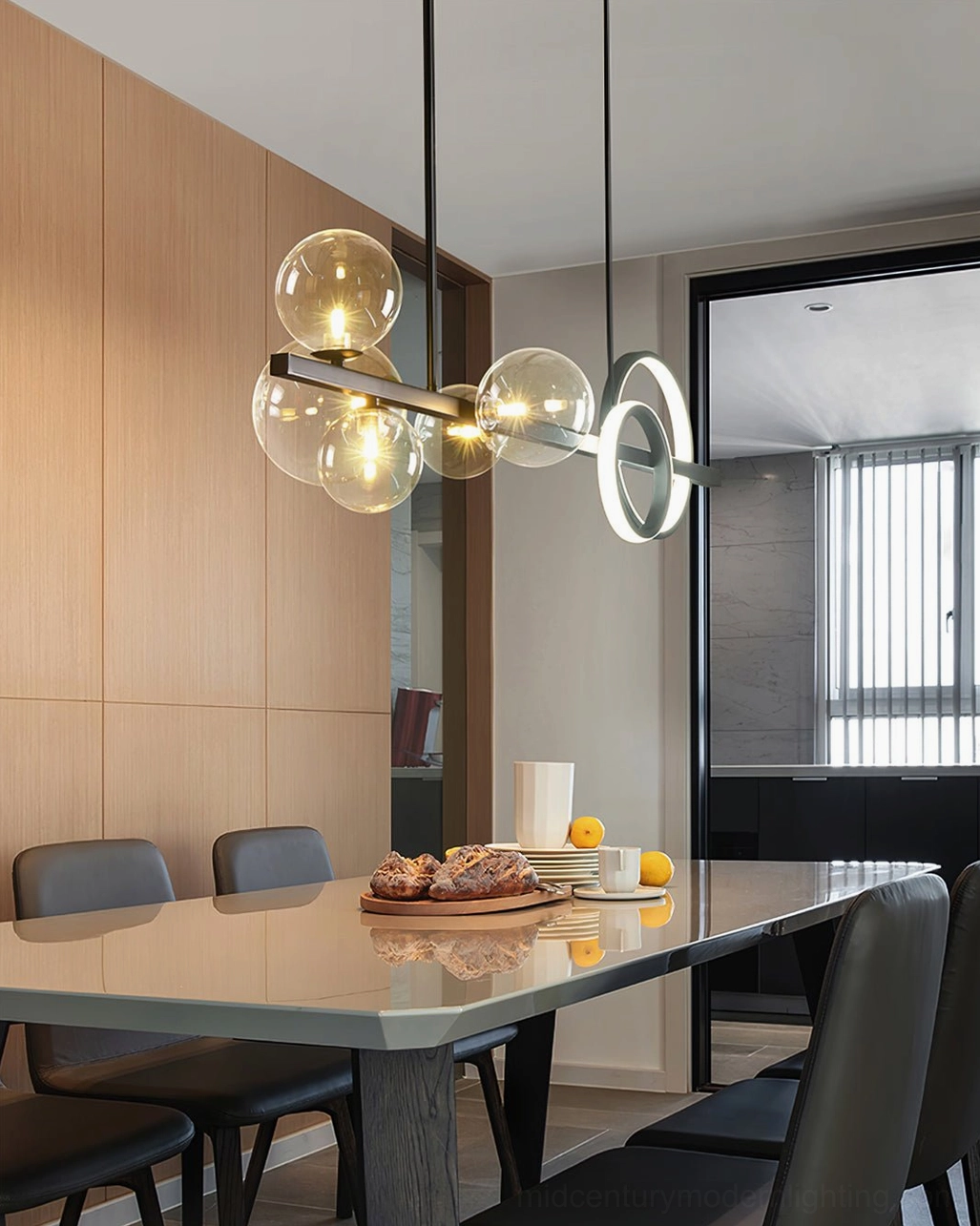 Modern glass bubble chandelier installation showing multiple glass orbs arranged along black metal suspension rod with warm LED illumination