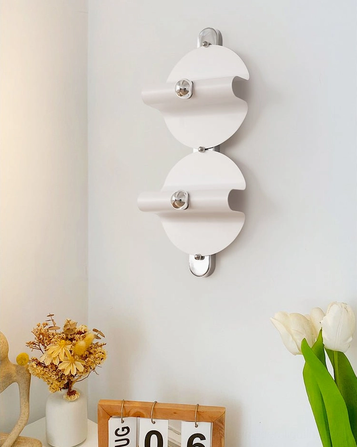 Two illuminated minimalist wall sconces with warm ambient lighting in styled interior corner