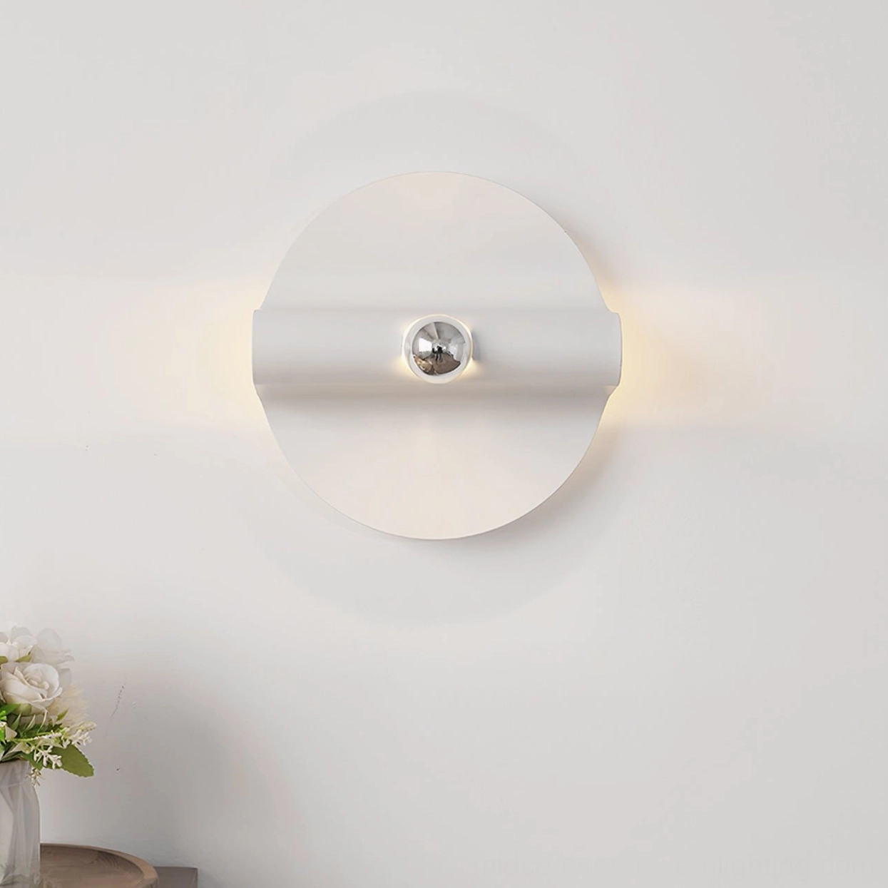 Single illuminated minimalist wall lamp with warm glow, white base and chrome fixture in interior setting