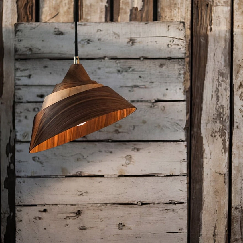 Close-up frontal view of tapered wooden Moku pendant lamp glowing with warm light in rustic vintage interior with exposed wood