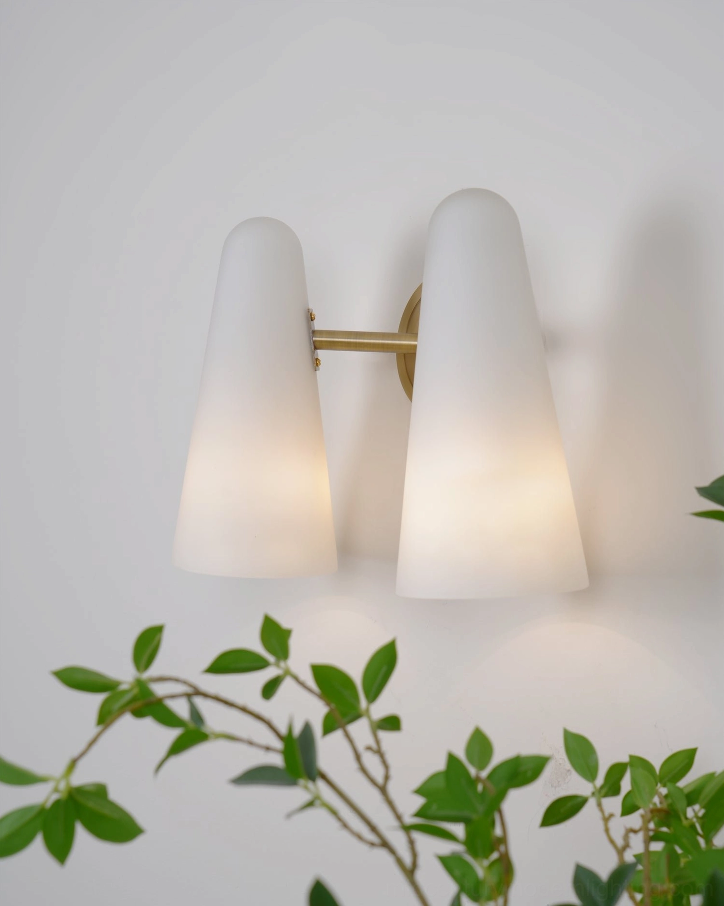 Montfaucon brass wall sconce with frosted glass shade creating ambient mood lighting