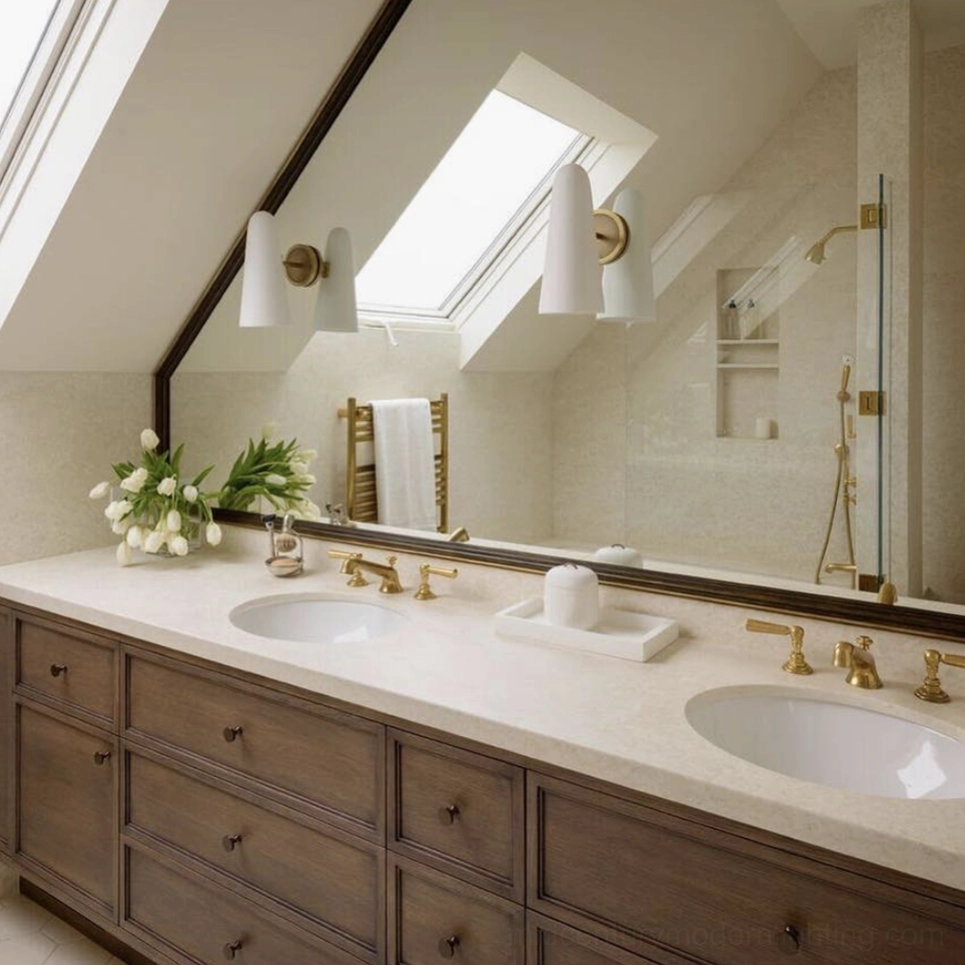 Paired Montfaucon wall sconces in modern attic bathroom with dual brass fixtures and wood vanity mirror