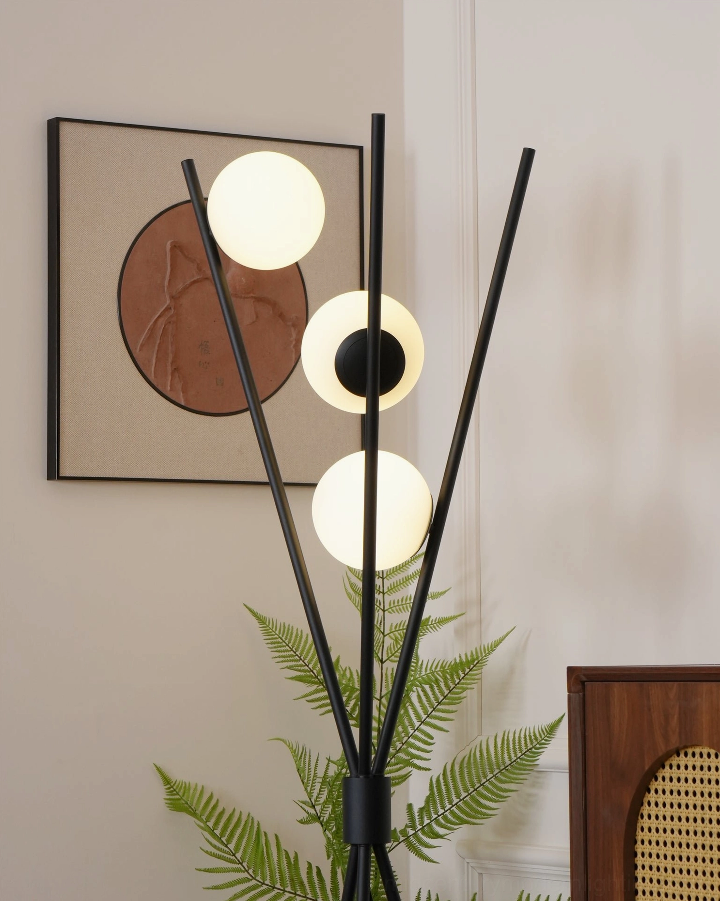 Close-up detail of Moon Floor Lamp with glowing white frosted glass shades and circular wall art