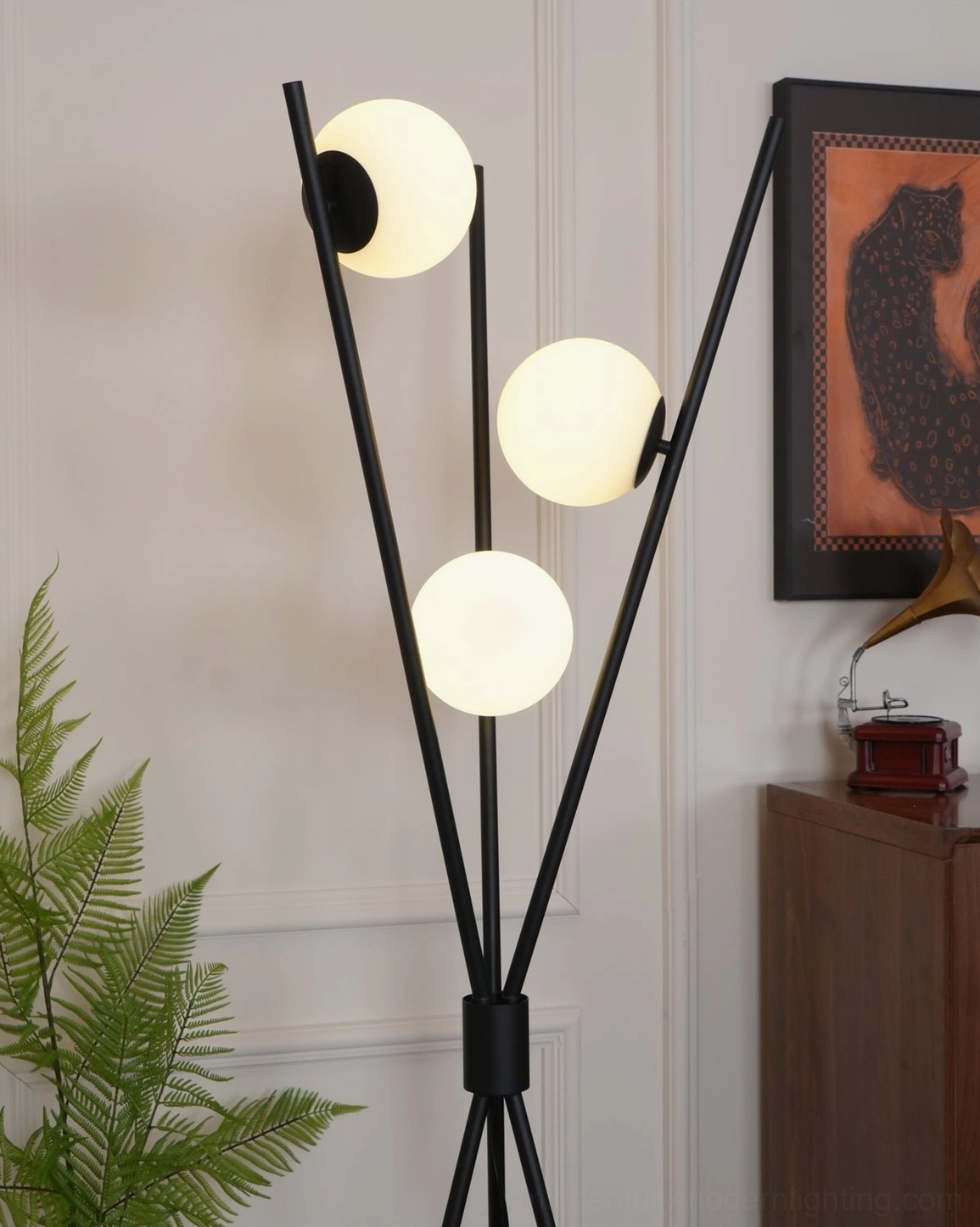 Warm illuminated Moon Tripod Floor Lamp showing frosted glass globe diffusion in vintage interior