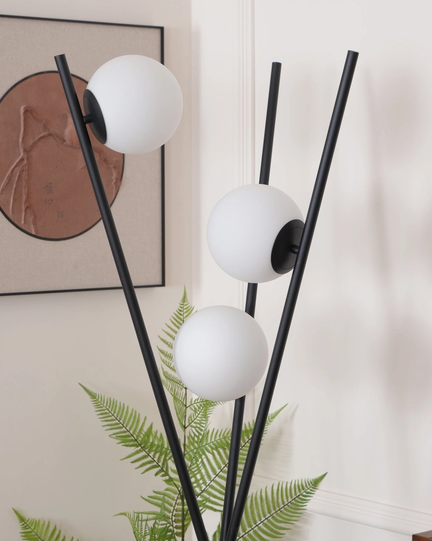 Unlit Moon Tripod Floor Lamp close-up highlighting matte black metal rods and plain frosted white glass