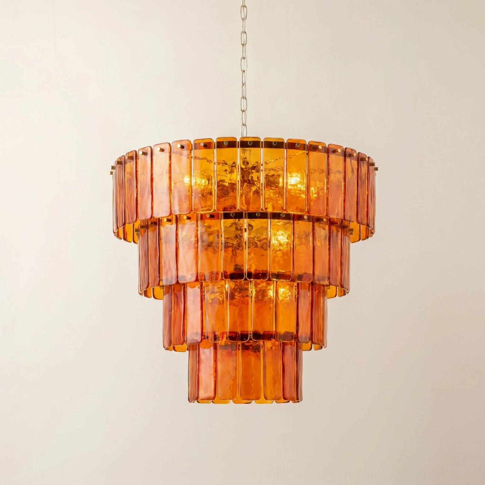 Moreland three-tier amber glass chandelier illuminated with warm light diffusion