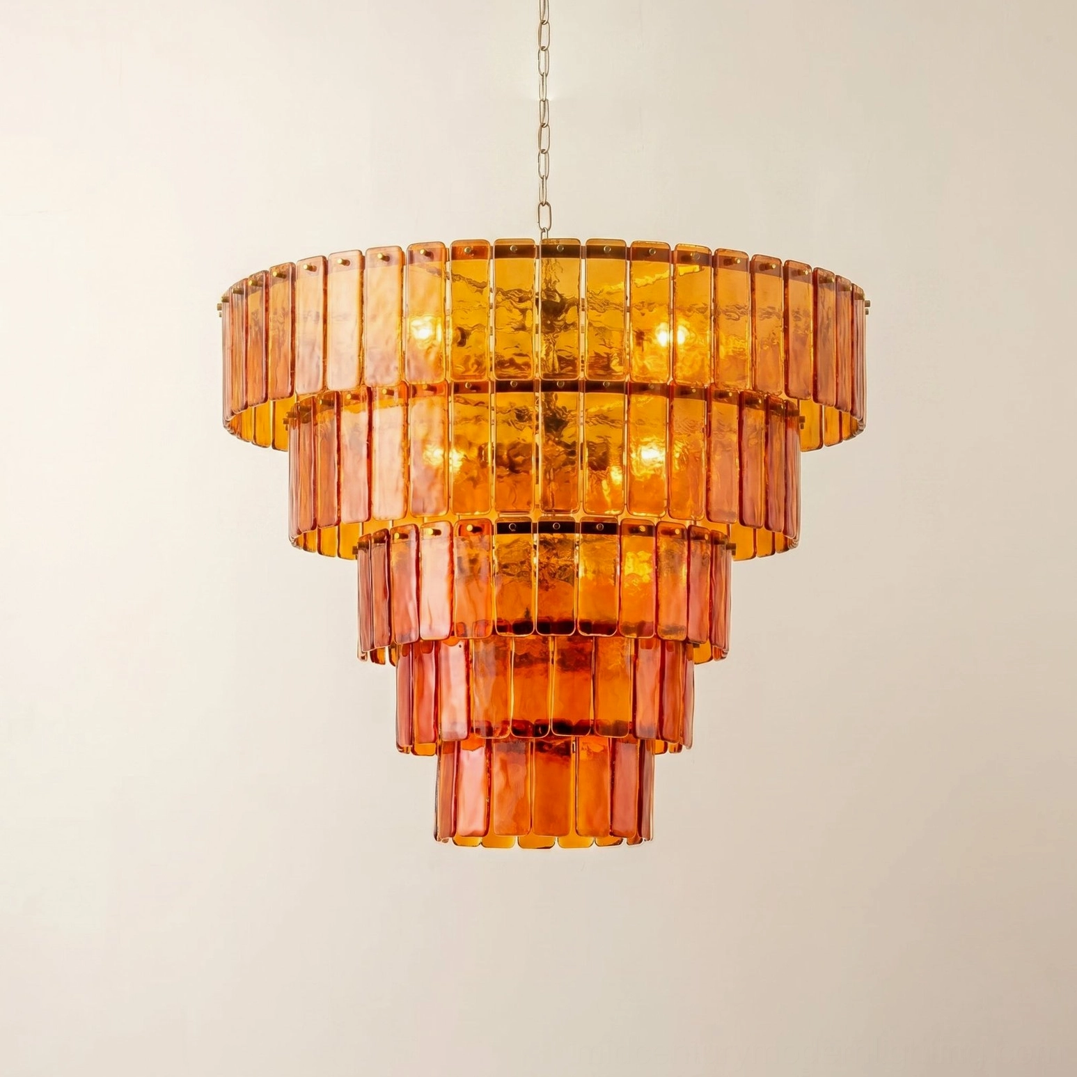 Moreland tiered glass chandelier angled view showing symmetrical hand-cast amber panels