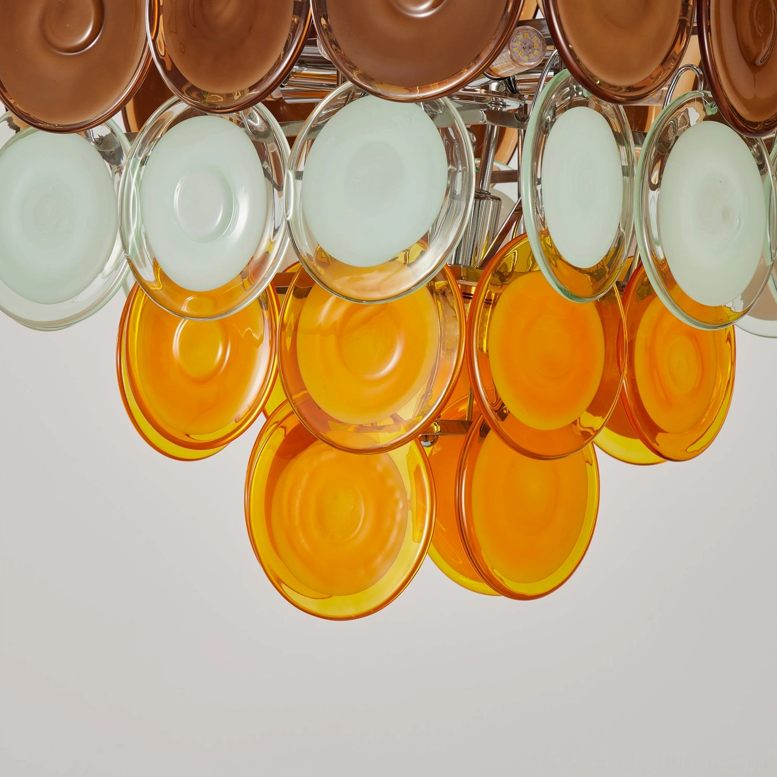 Close-up of lower Mortimer chandelier sections featuring pale mint and bright orange glass disc pieces