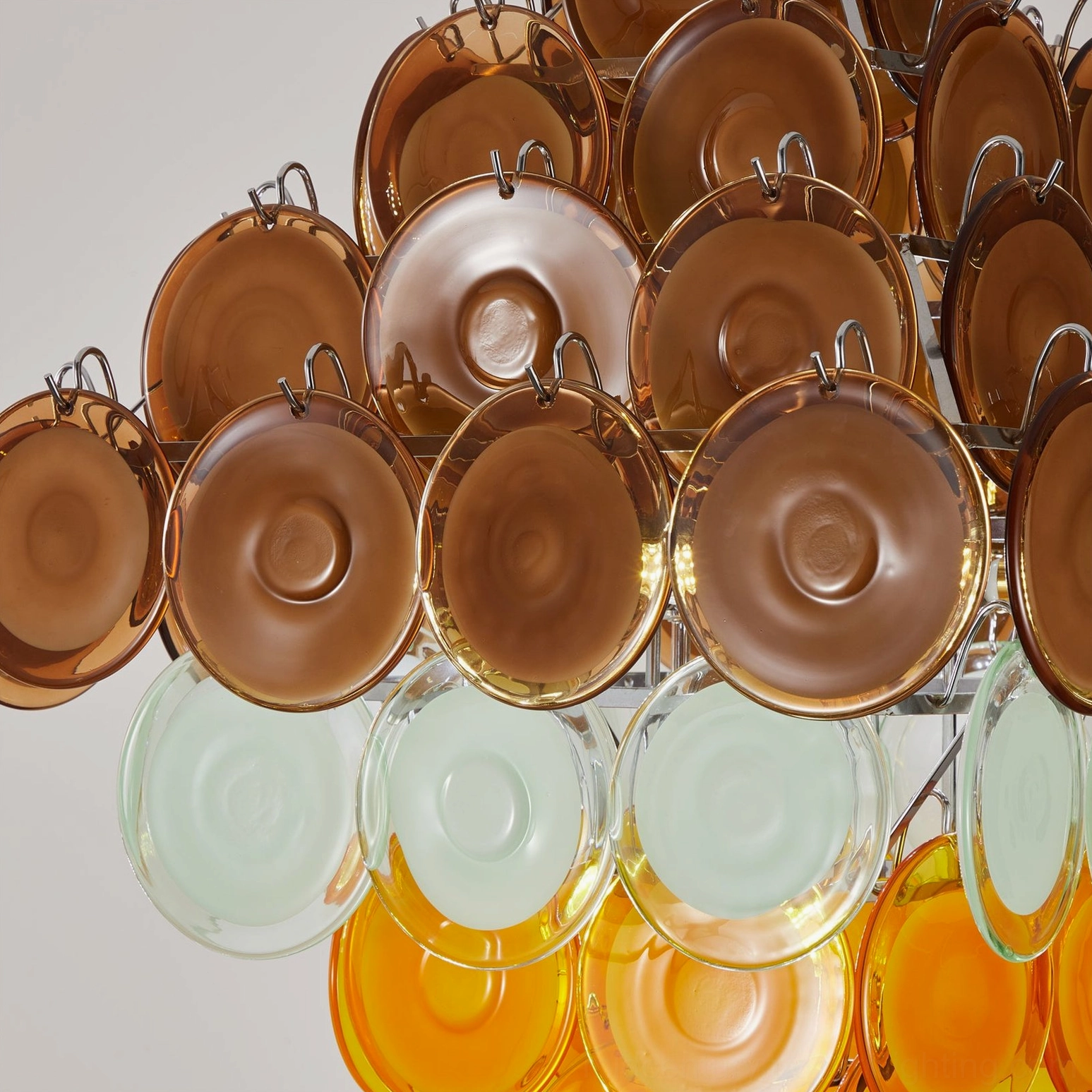Upper sections of Mortimer chandelier close-up showing brown amber glass discs with chrome hanging fixtures