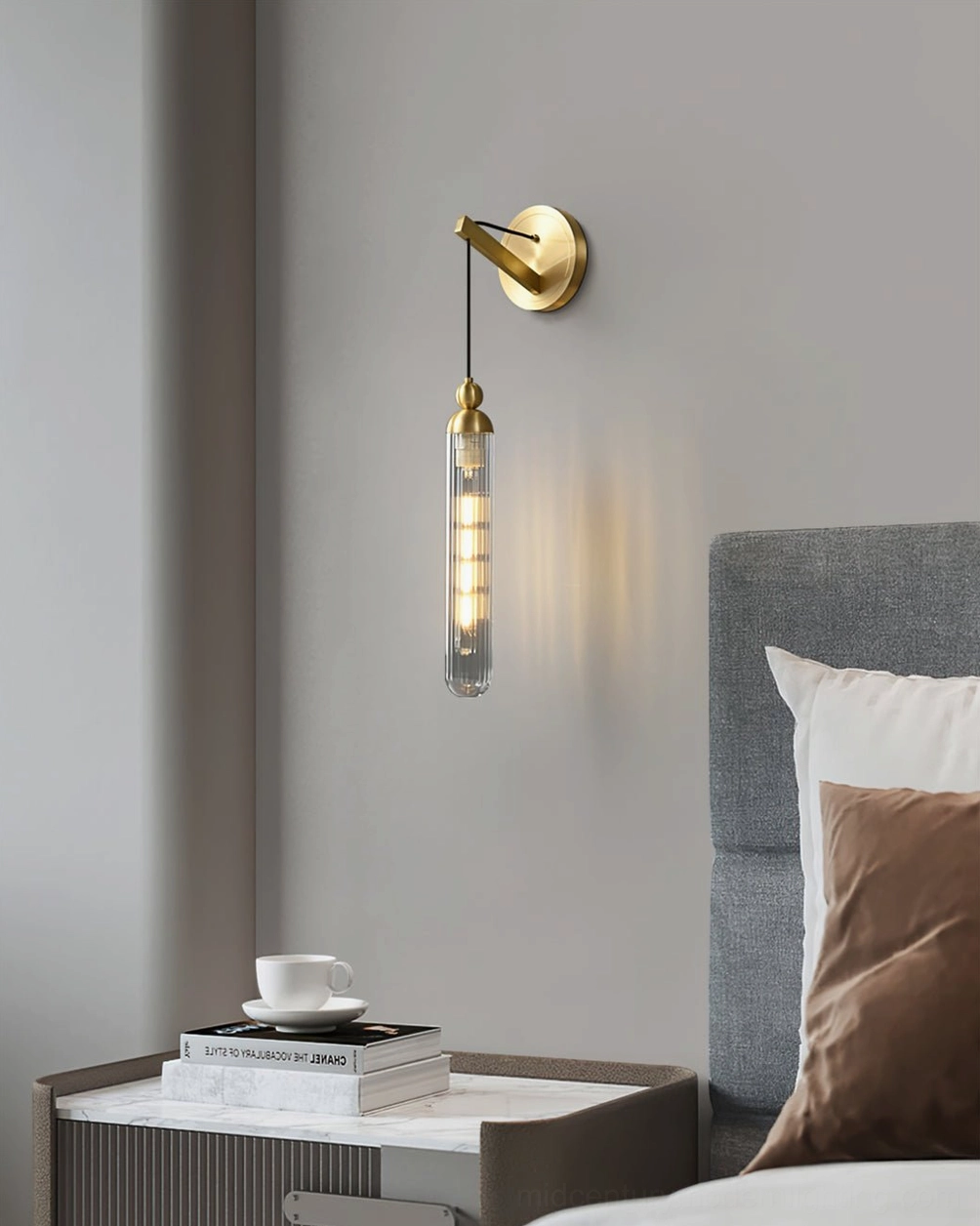 Brushed brass Mullan wall lamp with clear glass in luxury modern bedroom ambiance