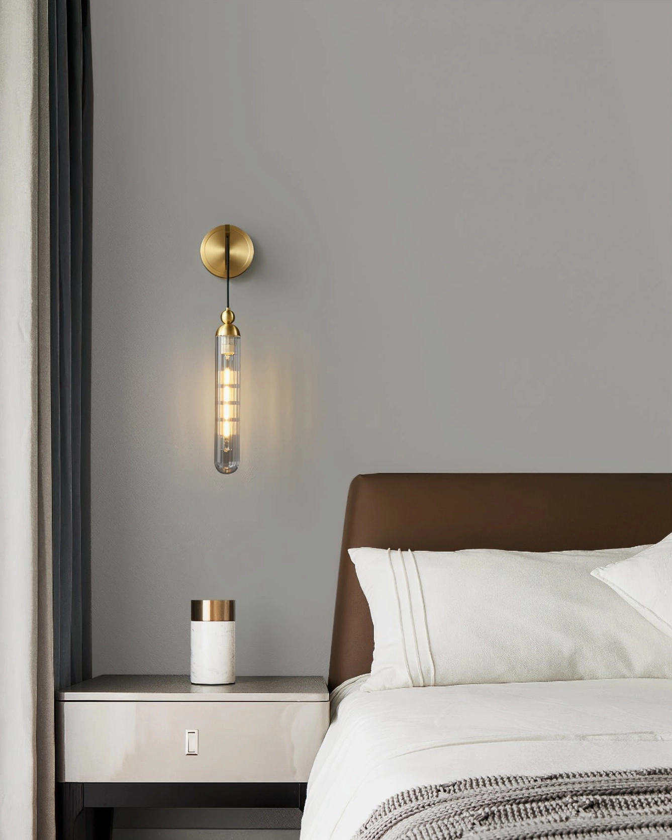Brass Mullan minimalist wall sconce clear cylindrical glass luxury bedroom interior