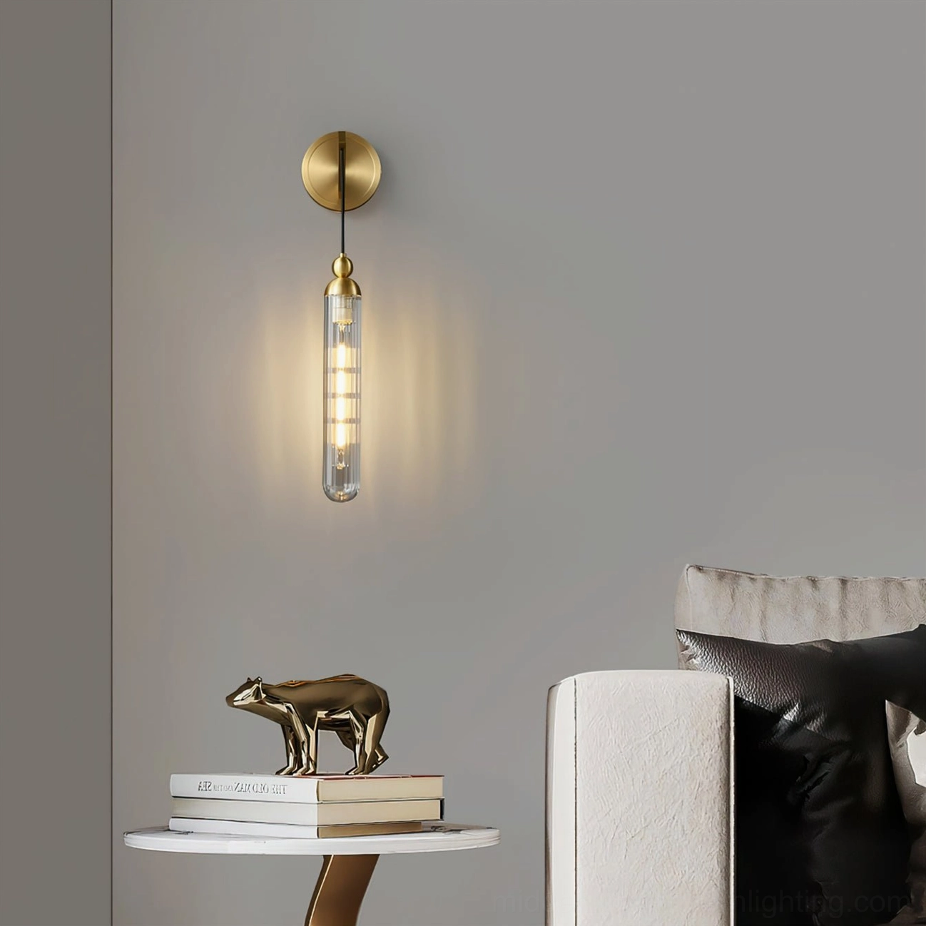 Brushed brass Mullan wall sconce in modern living room, cylindrical glass pendant design illuminated