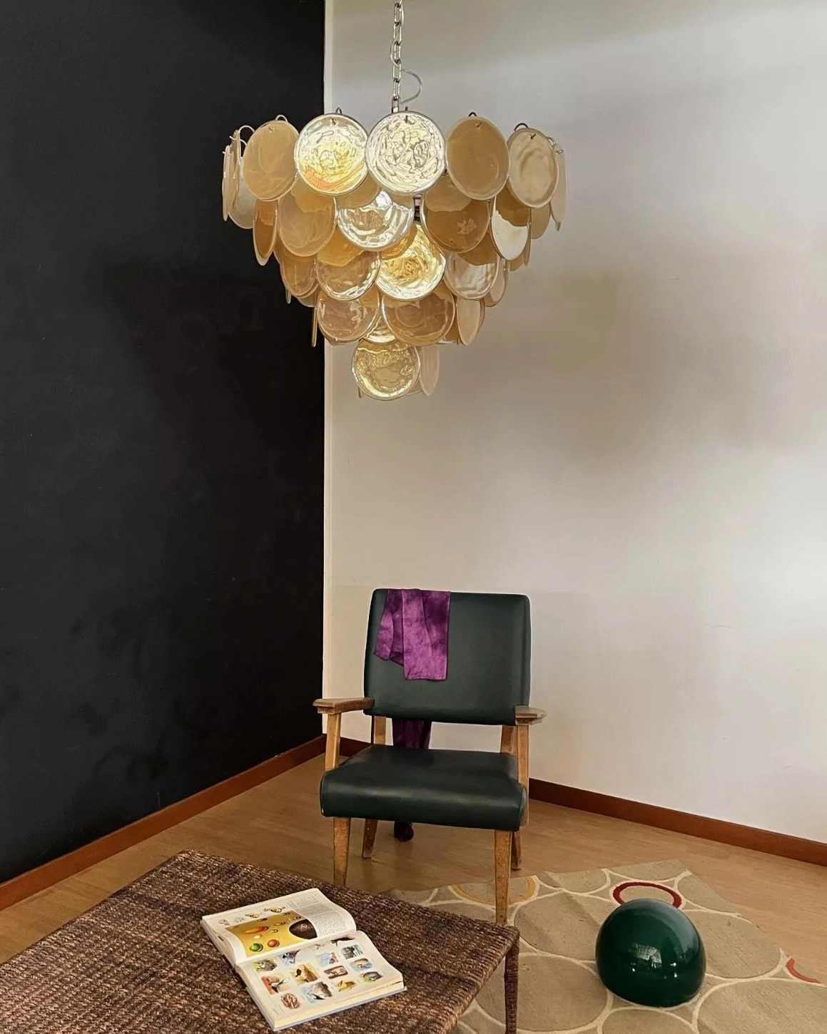 Mid-century modern chandelier suspended in residential sitting area with matching green armchair and home decor