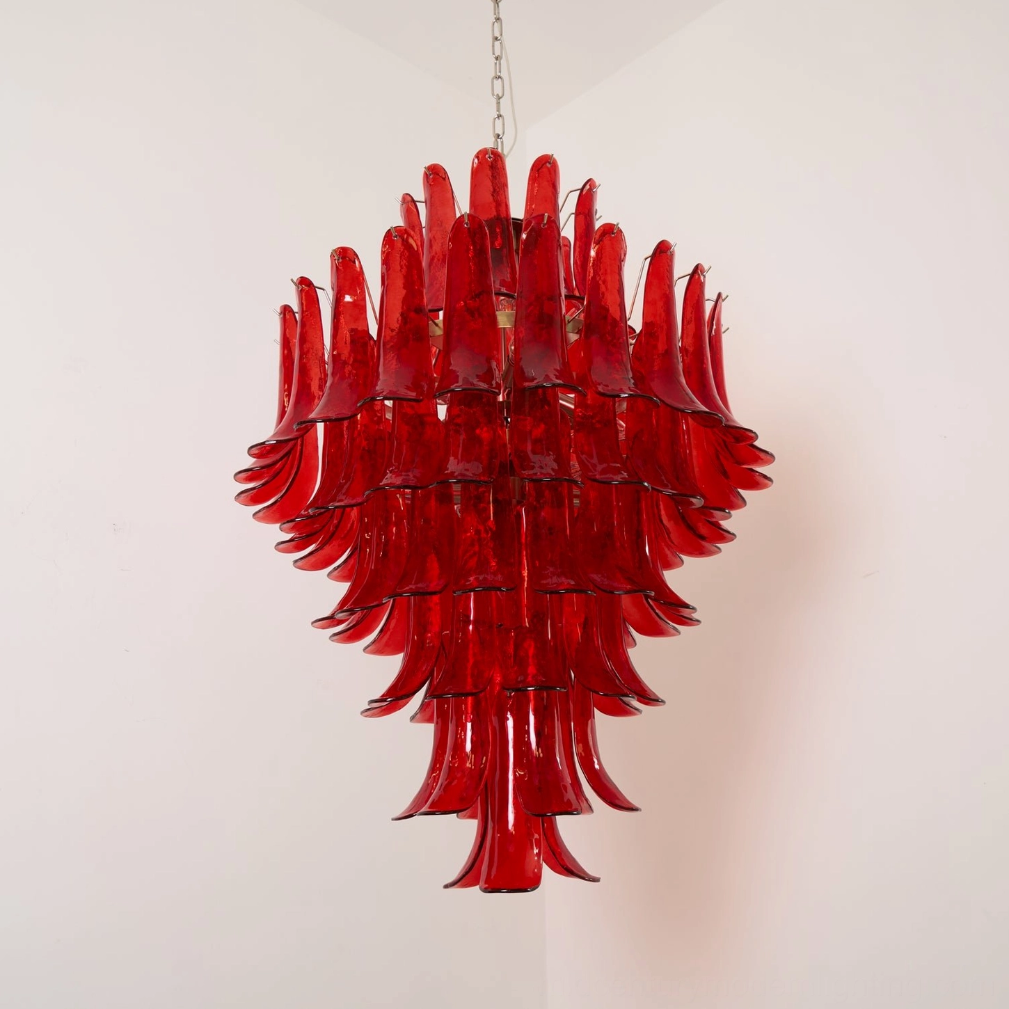 Overhead lit detail of Murano glass chandelier showing illuminated interior lamps and dense stacked glass petals with gold-toned metal supports