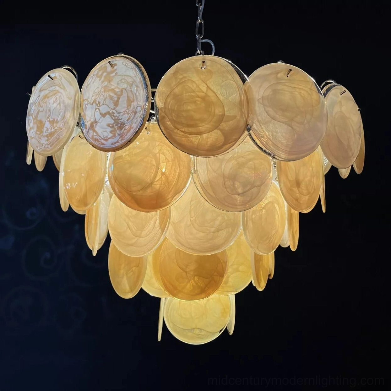 Overhead close-up of vintage Murano chandelier showing layered warm amber and clear marbled glass disc structure