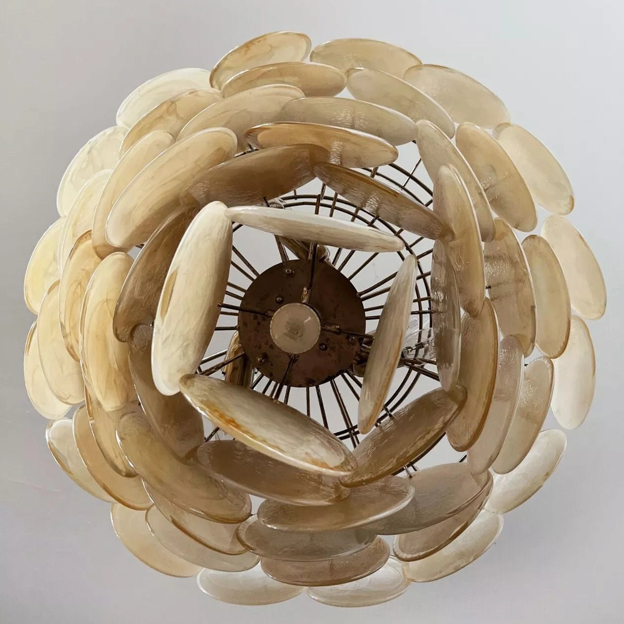 Vintage yellow Murano glass chandelier with chrome fixtures demonstrating warm light diffusion and tiered design aesthetic
