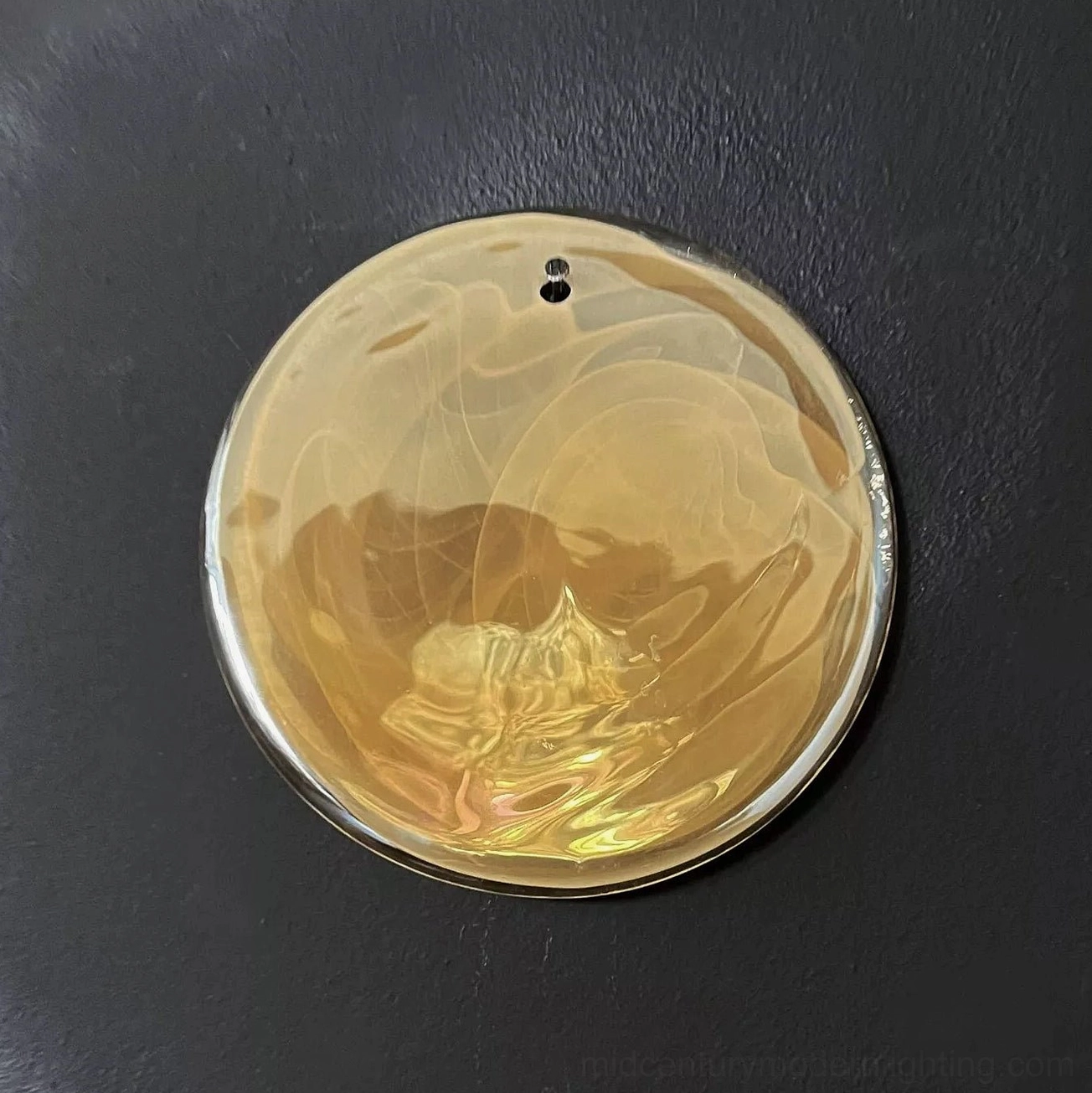 Single marbled amber glass disc accessory with silver metal rim showing hanging hardware detail