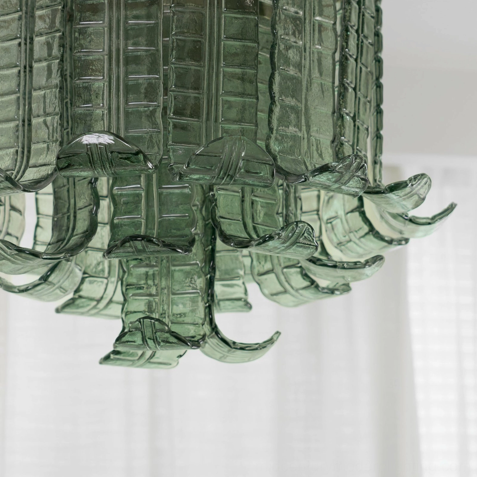 Textured glass ceiling lamp illuminated detail, light diffusion through leaf panels, warm ambient effect